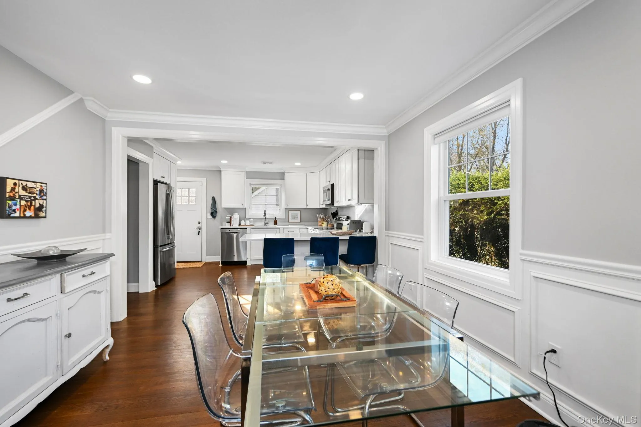 Framed by elegant header molding and adorned with classic wainscoting, this beautiful dining room features large windows and opens seamlessly to the kitchen—perfect for easy, stylish entertaining. Framed by elegant header molding and adorned with classic wainscoting, this beautiful dining room features large windows and opens seamlessly to the kitchen—perfect for easy, stylish entertaining.