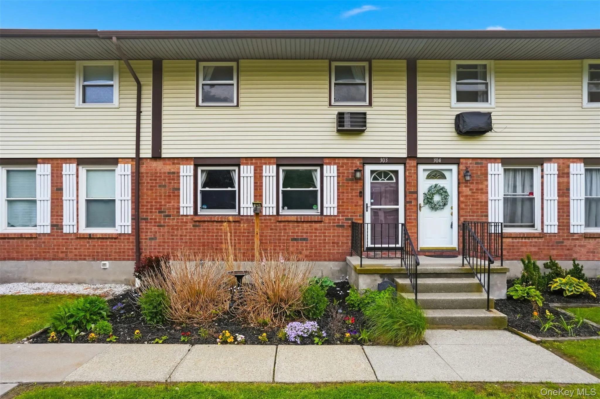Brick and siding exterior featuring white louvered shutters and multiple windows Brick and siding exterior featuring white louvered shutters and multiple windows