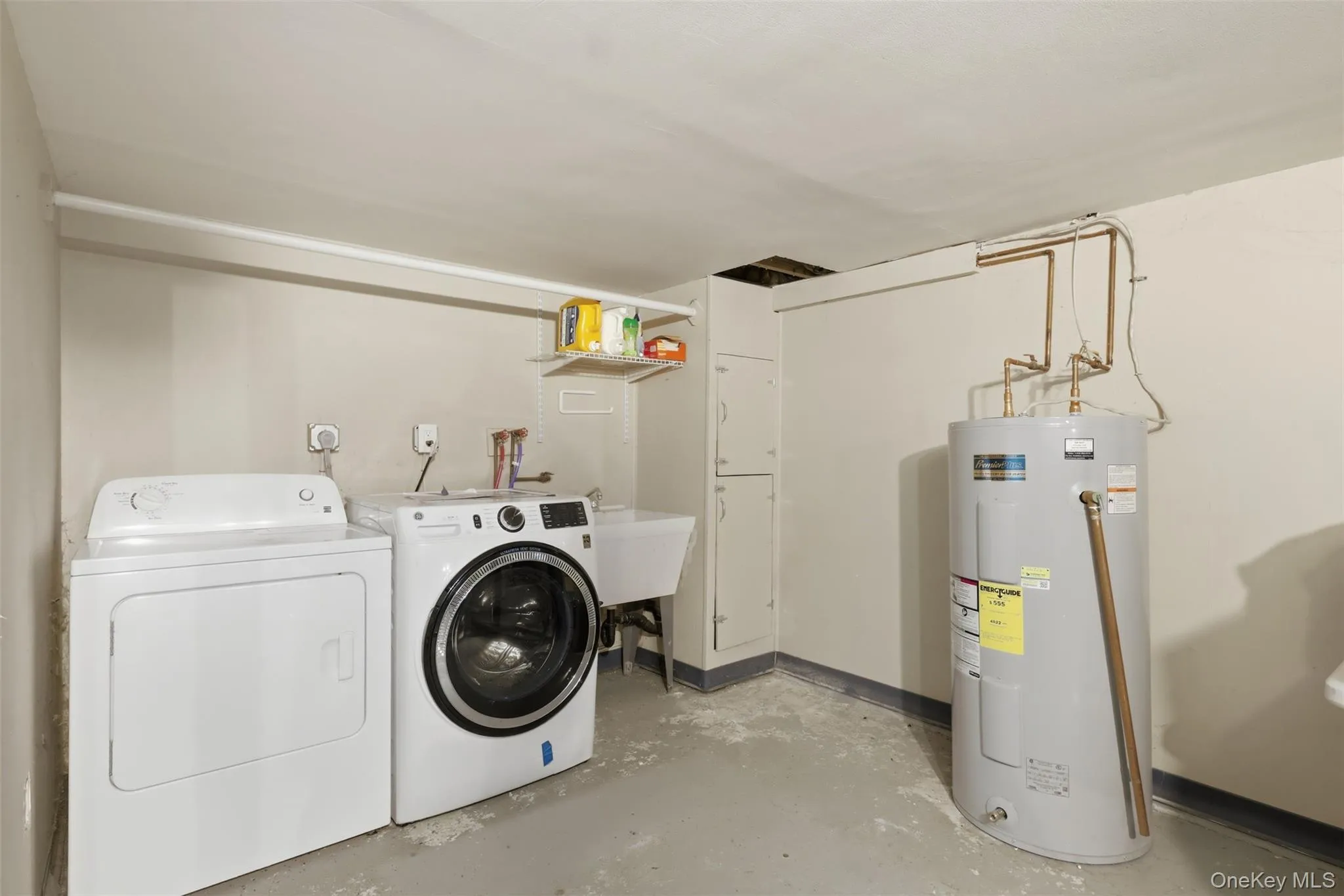 Dedicated laundry area featuring a white top-load washing machine, front-load washing machine, and utility sink Dedicated laundry area featuring a white top-load washing machine, front-load washing machine, and utility sink