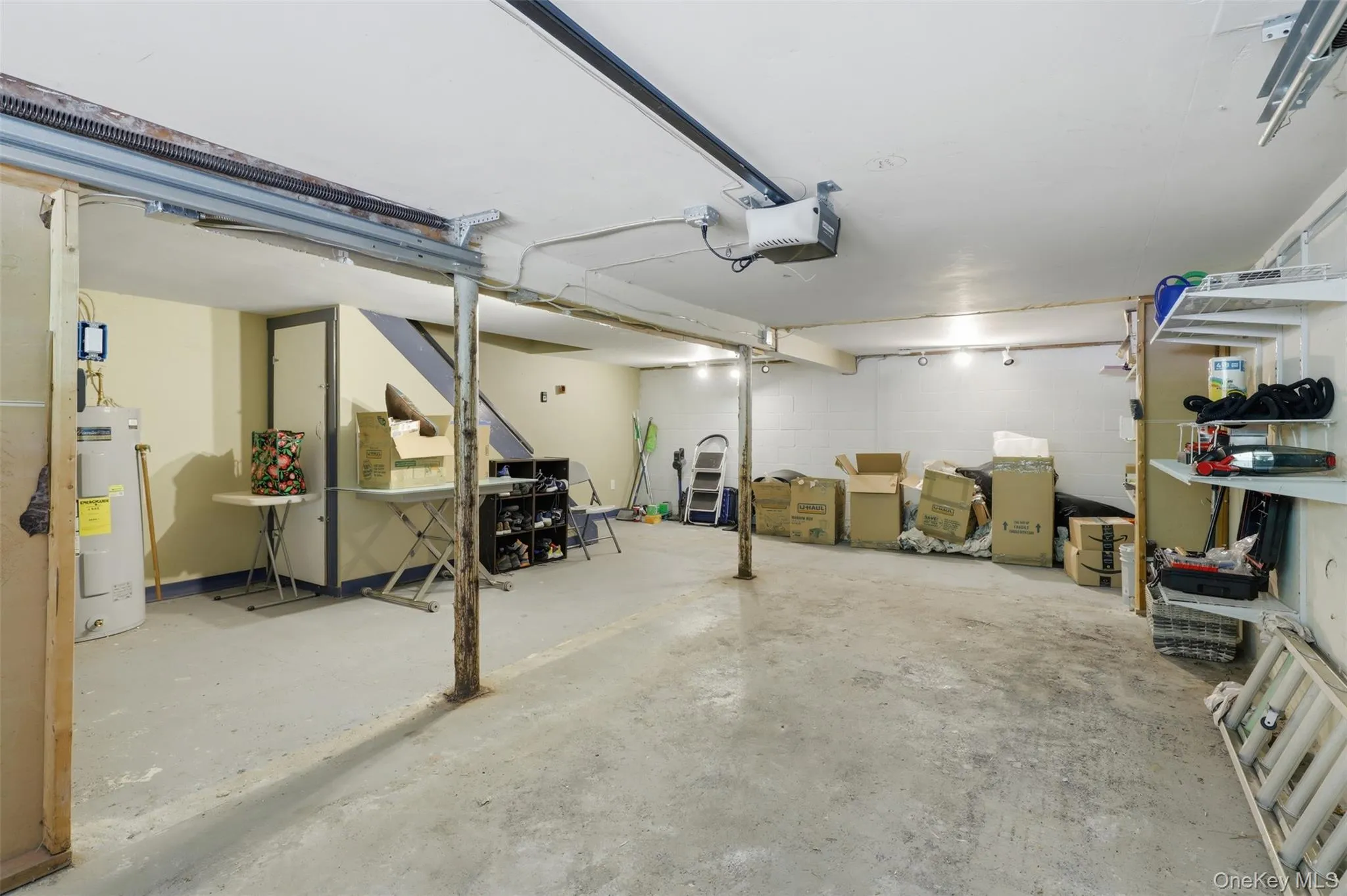 Unfinished basement area featuring a concrete floor, remote garage door opener Unfinished basement area featuring a concrete floor, remote garage door opener