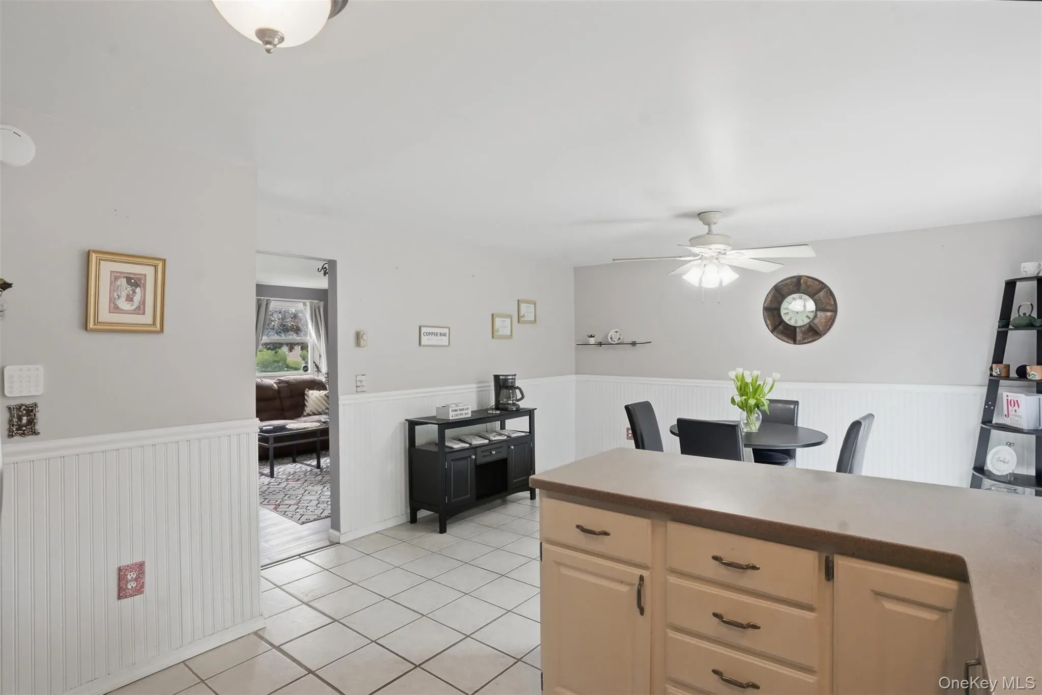Open kitchen area featuring ceramic tile flooring, light neutral cabinetry , and a ceiling fan with integrated lighting Open kitchen area featuring ceramic tile flooring, light neutral cabinetry , and a ceiling fan with integrated lighting