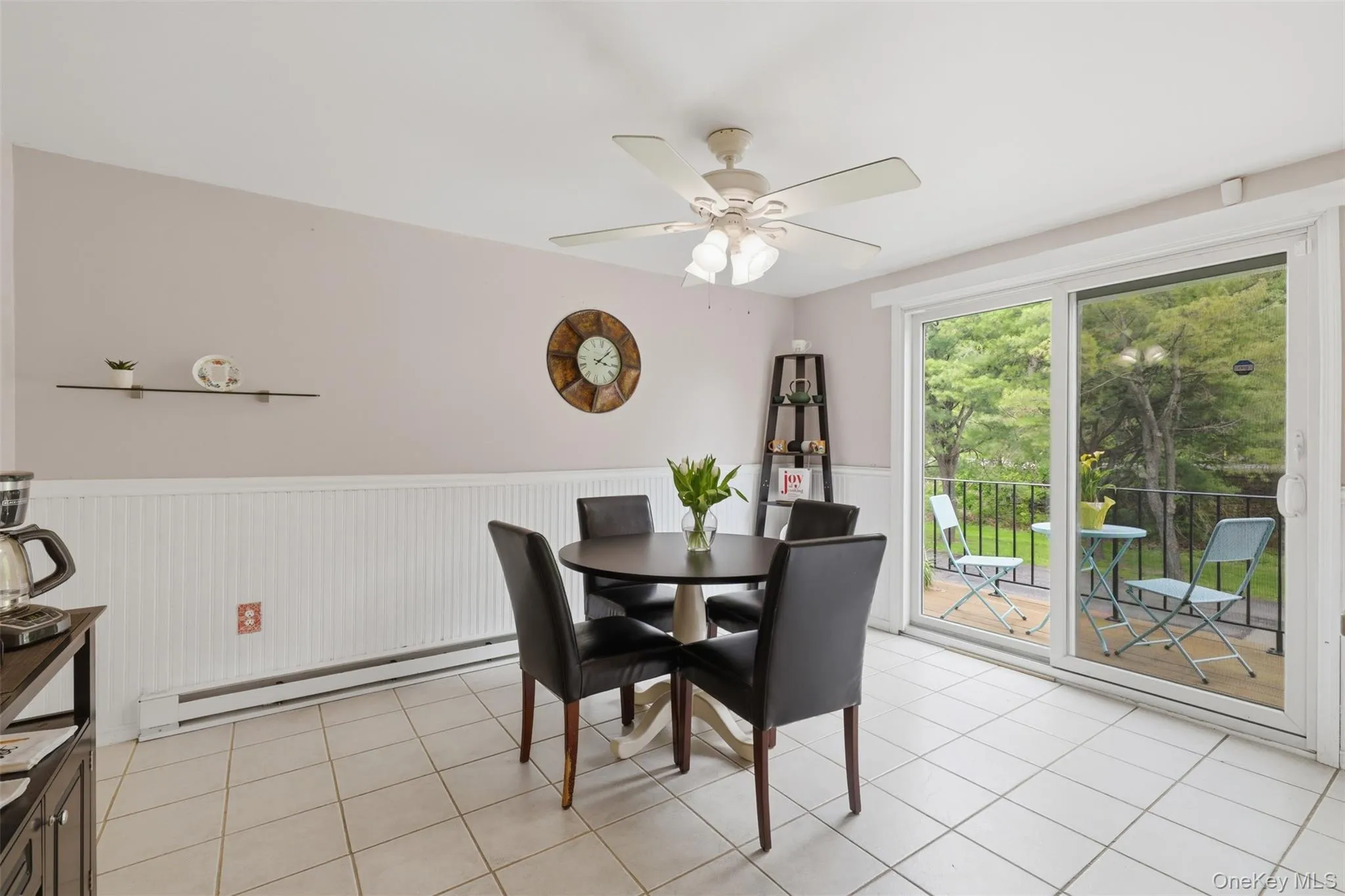 Tiled flooring and wainscoting highlight this dining area, featuring a ceiling fan with integrated lighting Tiled flooring and wainscoting highlight this dining area, featuring a ceiling fan with integrated lighting