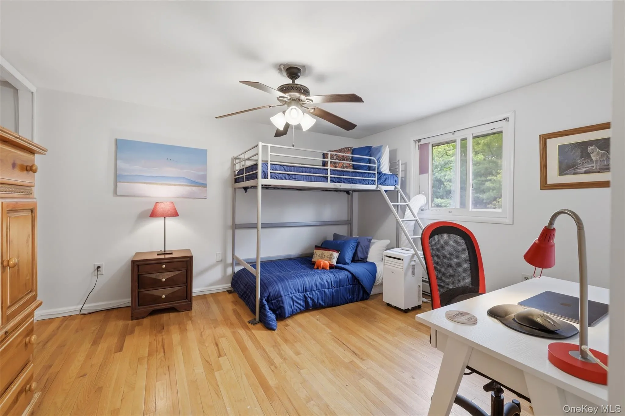 Room featuring wood-finish flooring, a ceiling fan with integrated lighting, and white walls Room featuring wood-finish flooring, a ceiling fan with integrated lighting, and white walls