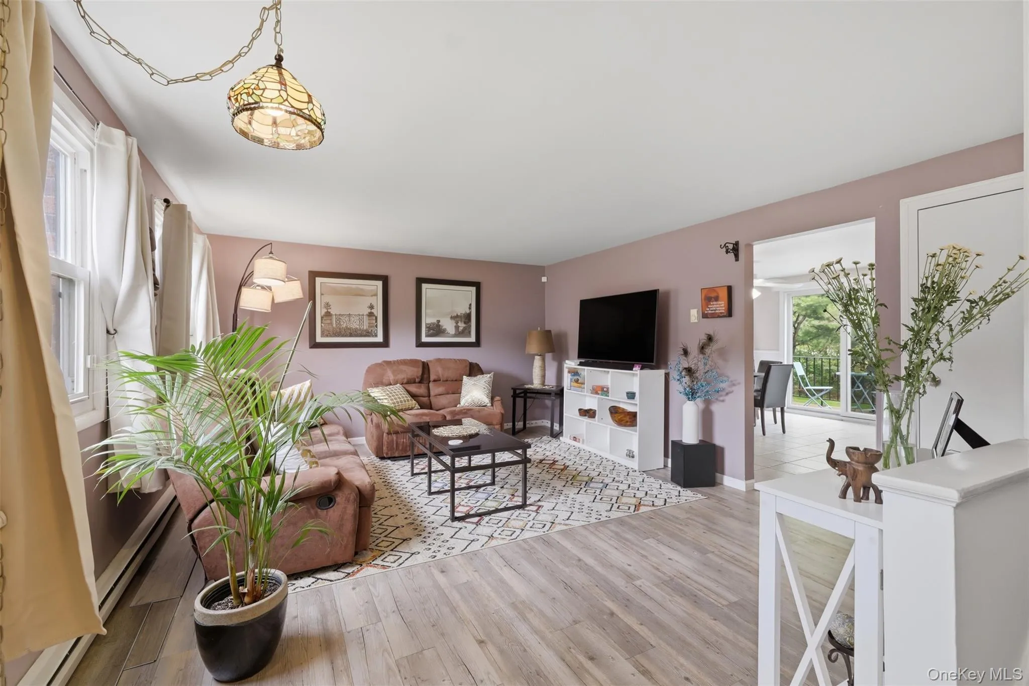 Spacious living area a decorative pendant light fixture, and an open doorway to a separate dining space Spacious living area a decorative pendant light fixture, and an open doorway to a separate dining space