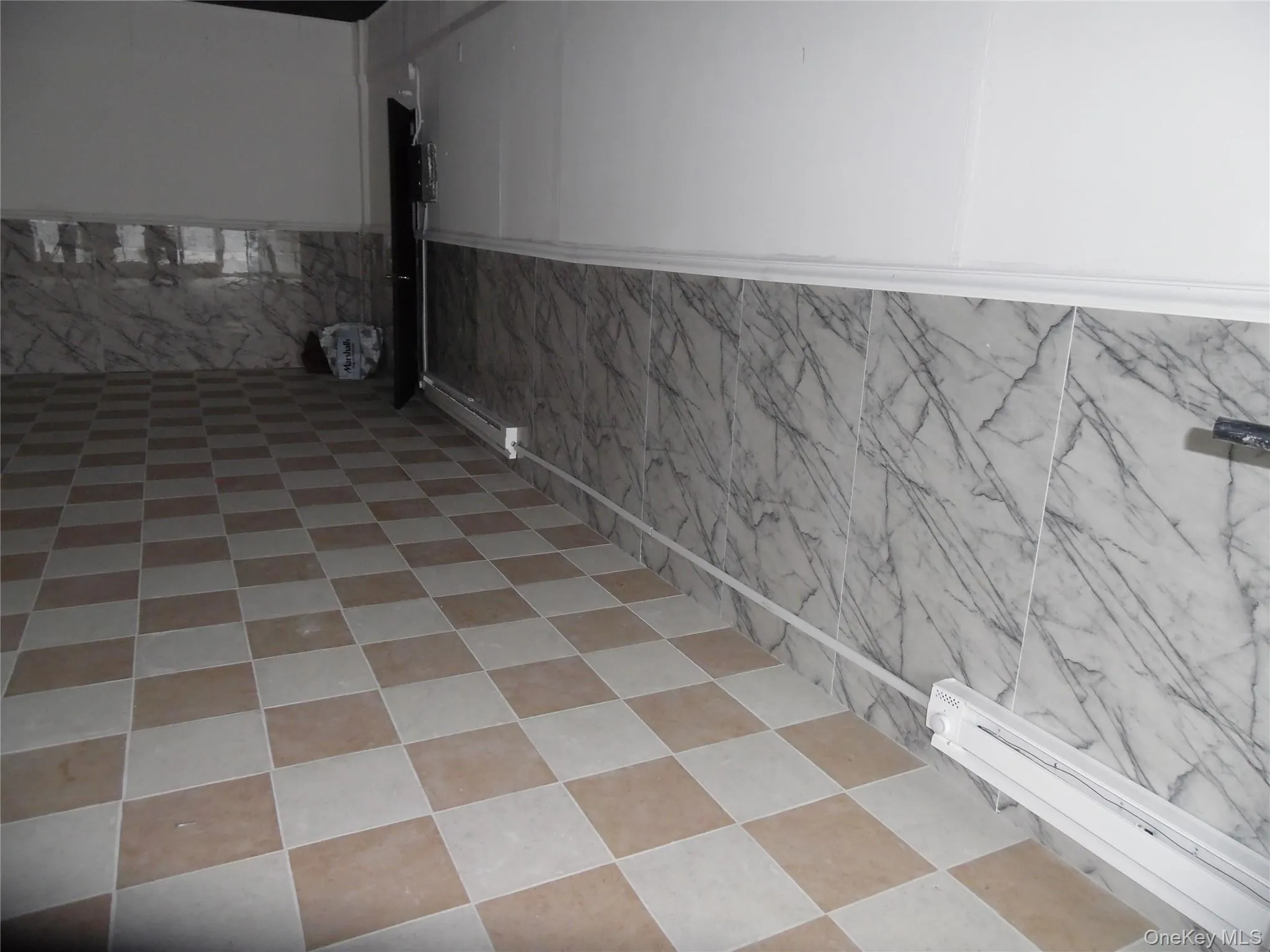 This room features checkered floor tiles and wall paneling with a marble-like pattern This room features checkered floor tiles and wall paneling with a marble-like pattern