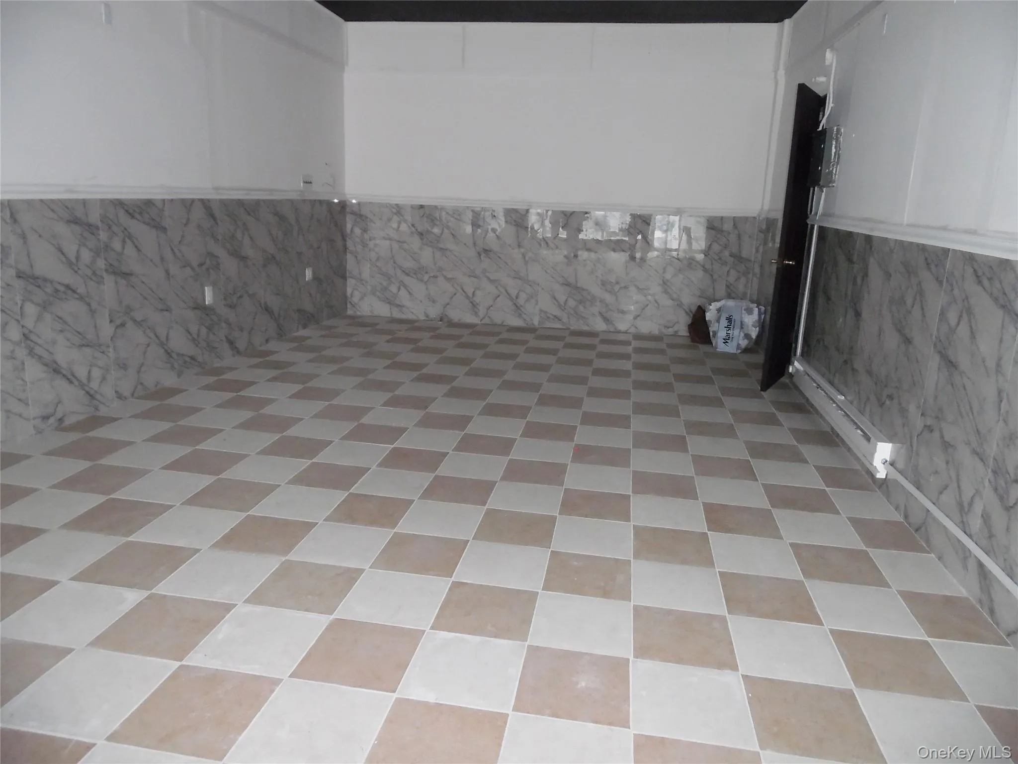 The property features a checkered tile floor, marble-patterned wall tiling, and white painted walls The property features a checkered tile floor, marble-patterned wall tiling, and white painted walls