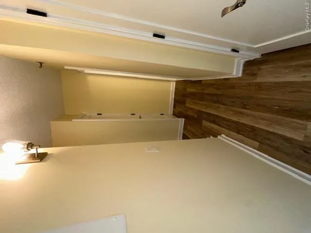 Corridor with baseboards, a textured ceiling, and dark wood finished floors Corridor with baseboards, a textured ceiling, and dark wood finished floors