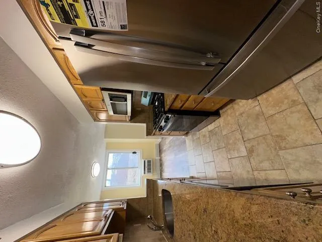 Kitchen with refrigerator, a textured ceiling, range with gas cooktop, decorative backsplash, and a sink Kitchen with refrigerator, a textured ceiling, range with gas cooktop, decorative backsplash, and a sink