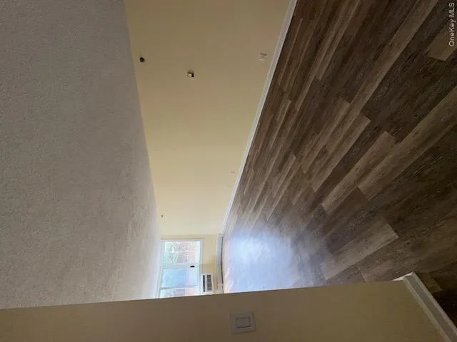 Unfurnished room with dark wood-style flooring, a textured ceiling, and baseboards Unfurnished room with dark wood-style flooring, a textured ceiling, and baseboards