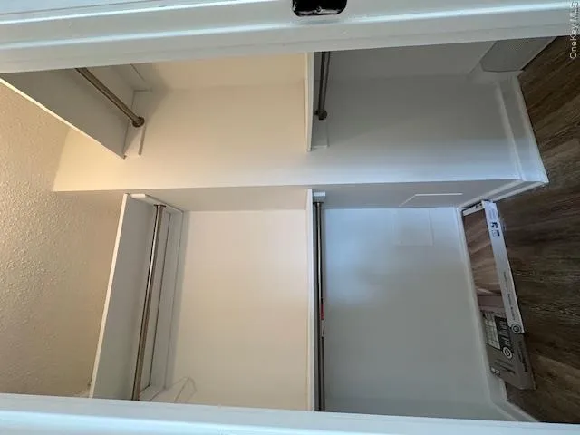 Walk in closet featuring wood finished floors Walk in closet featuring wood finished floors