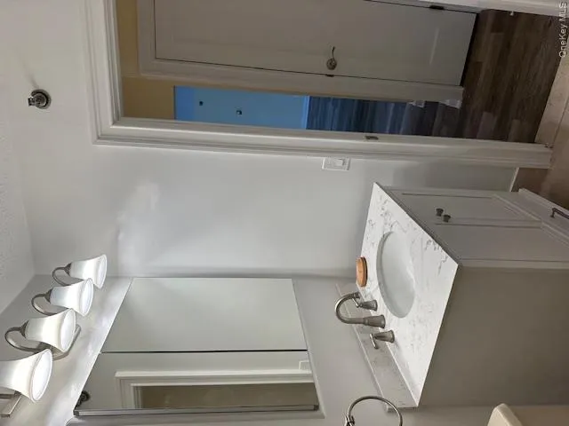 Half bath with vanity, wood finished floors, and a textured ceiling Half bath with vanity, wood finished floors, and a textured ceiling