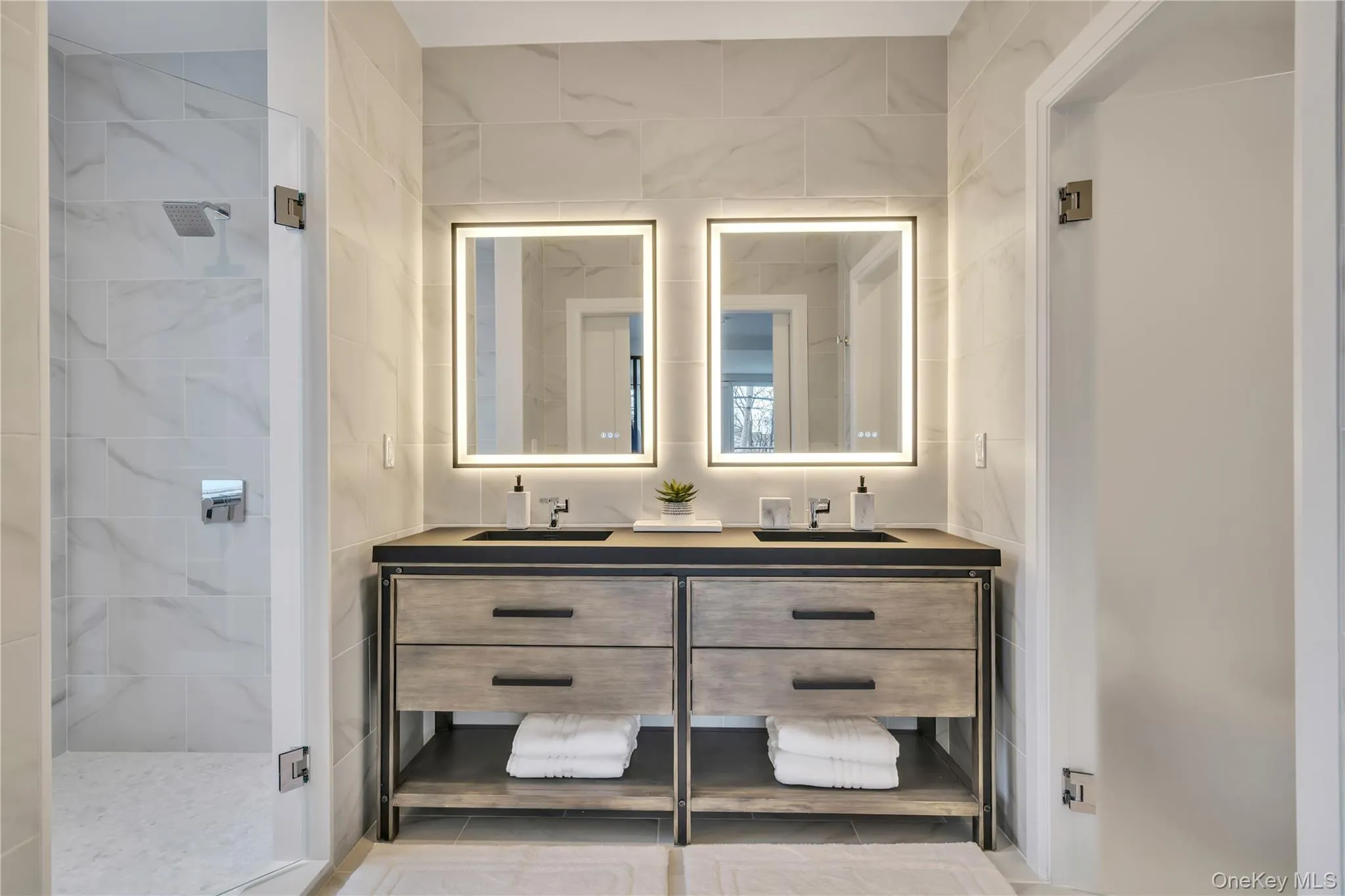Bathroom with double vanity, a sink, and tiled shower Bathroom with double vanity, a sink, and tiled shower