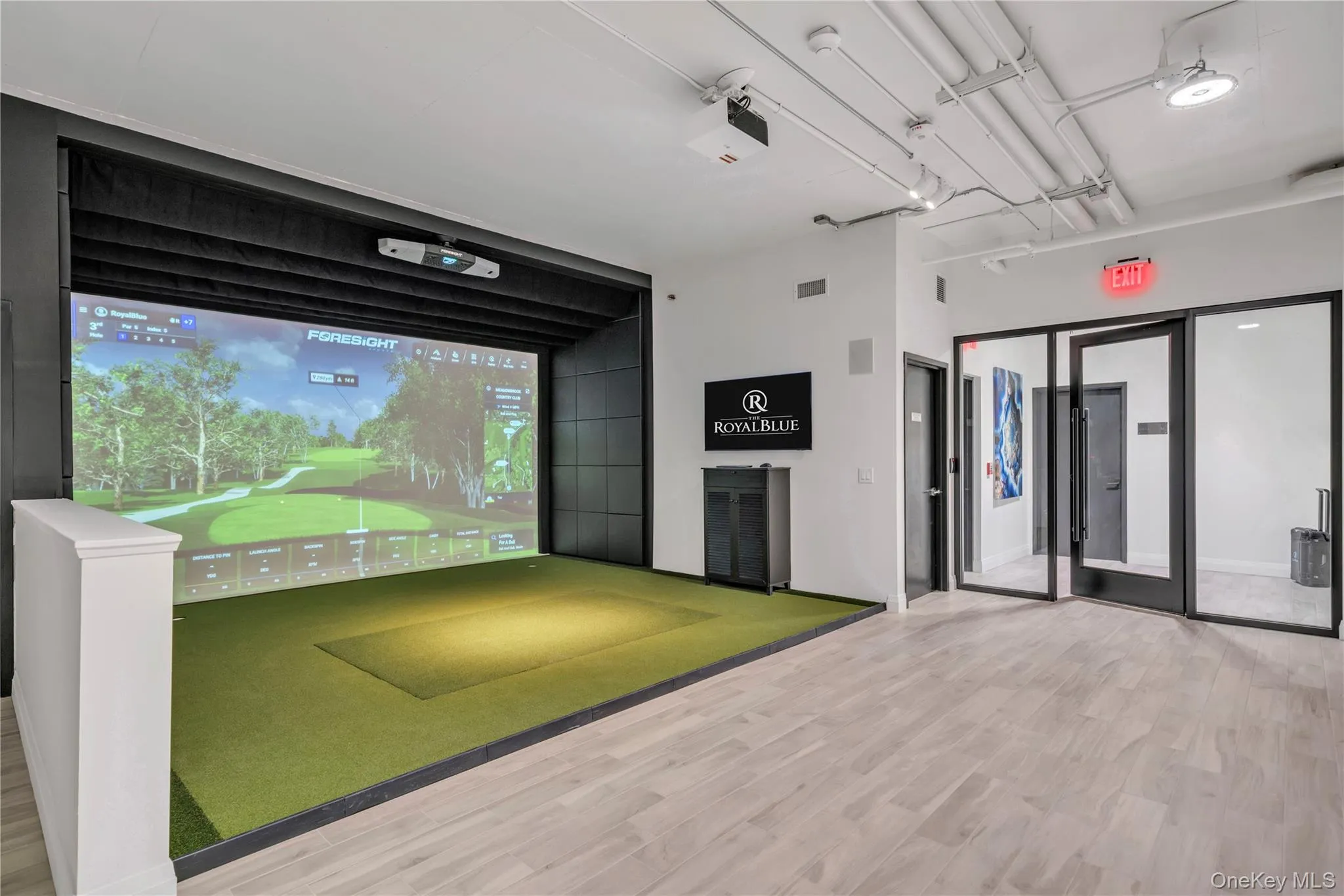Game room featuring visible vents, golf simulator, and wood finished floors Game room featuring visible vents, golf simulator, and wood finished floors