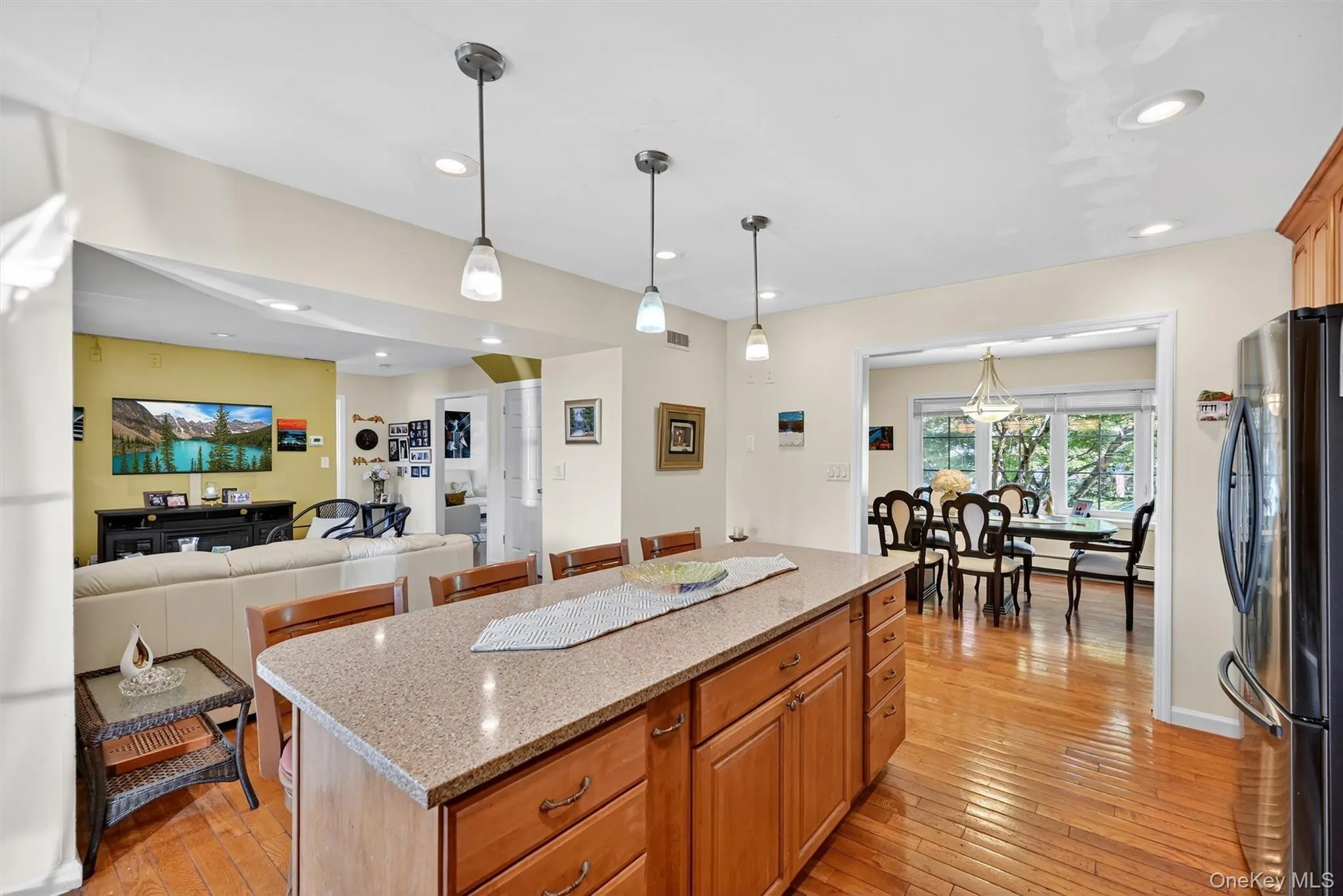 Kitchen with light stone countertops, pendant lighting, freestanding refrigerator, light wood-type flooring, and recessed lighting Kitchen with light stone countertops, pendant lighting, freestanding refrigerator, light wood-type flooring, and recessed lighting