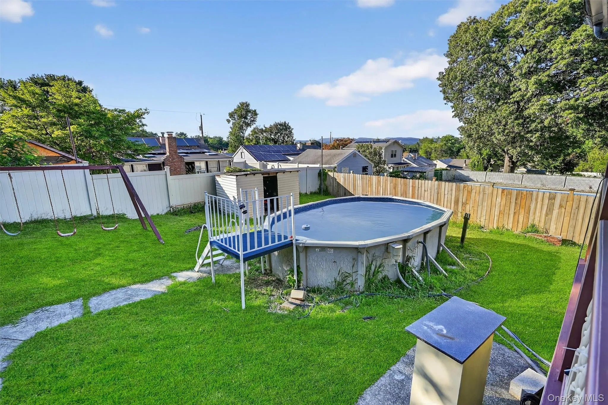 View of swimming pool with a fenced backyard, a residential view, and an outbuilding View of swimming pool with a fenced backyard, a residential view, and an outbuilding