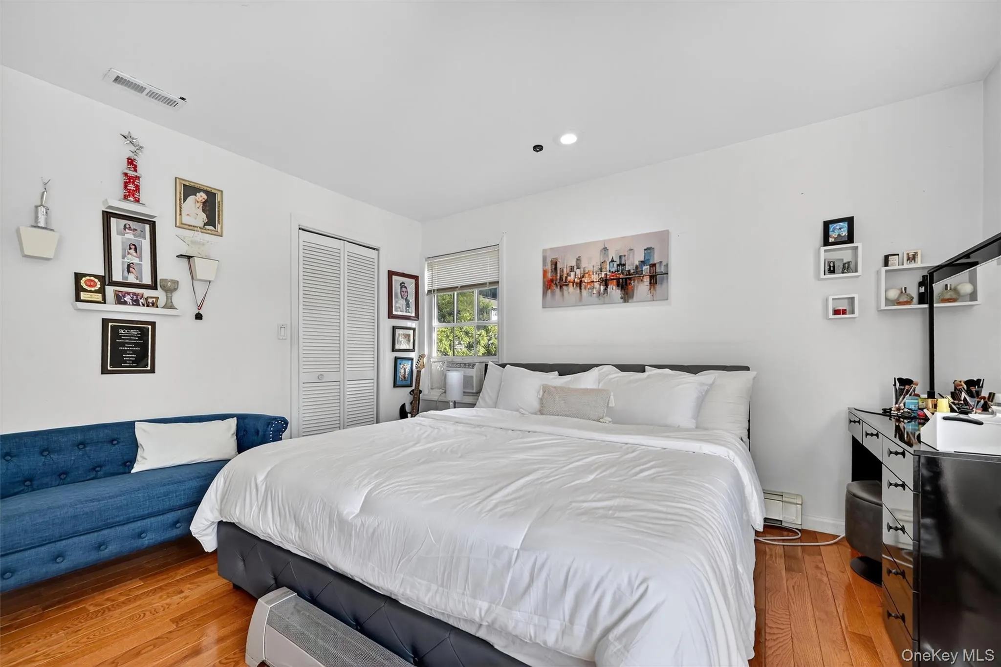 Bedroom with hardwood / wood-style flooring, a closet, recessed lighting, and black refrigerator Bedroom with hardwood / wood-style flooring, a closet, recessed lighting, and black refrigerator