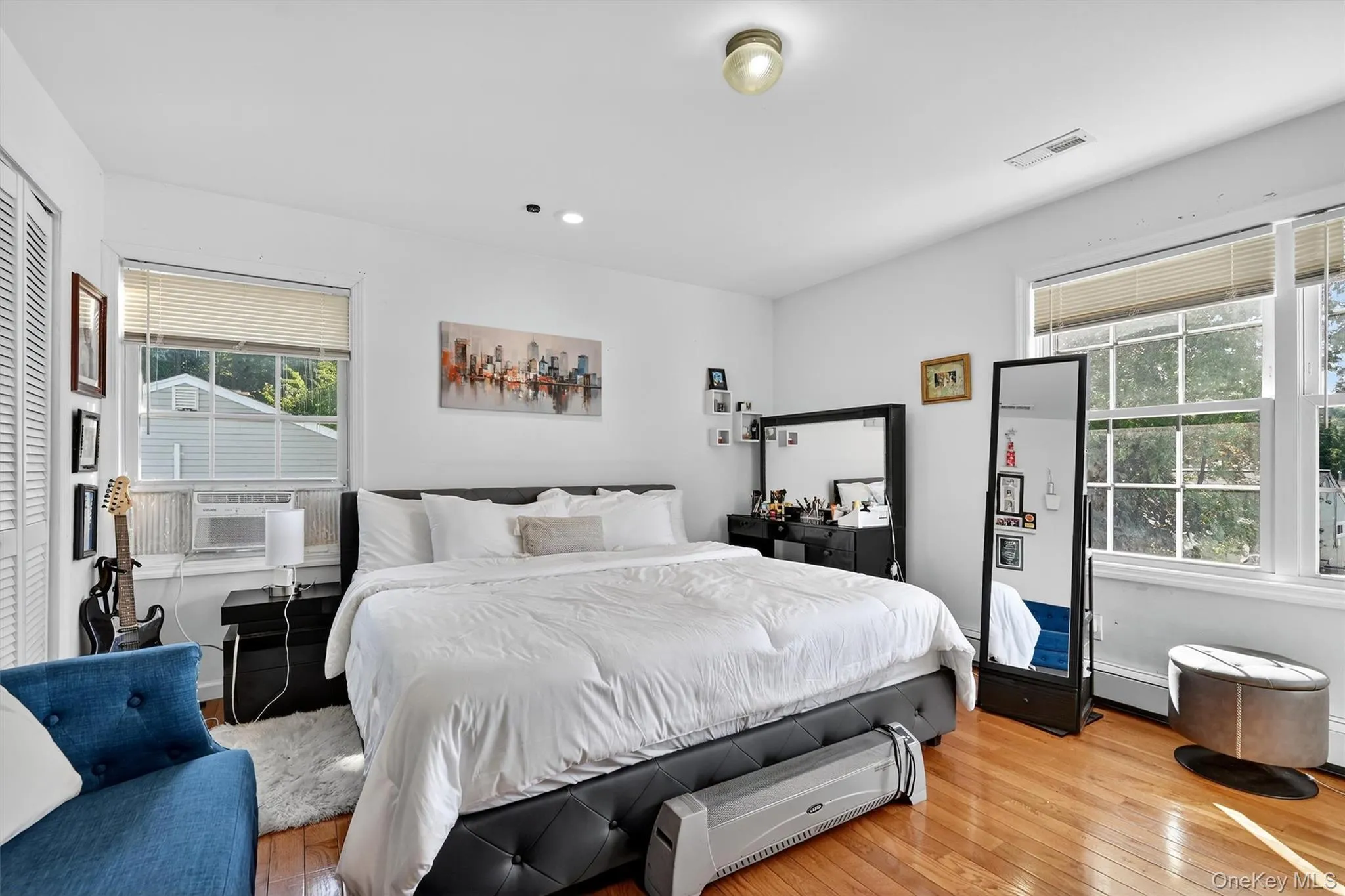 Bedroom with hardwood / wood-style floors, recessed lighting, and a baseboard heating unit Bedroom with hardwood / wood-style floors, recessed lighting, and a baseboard heating unit