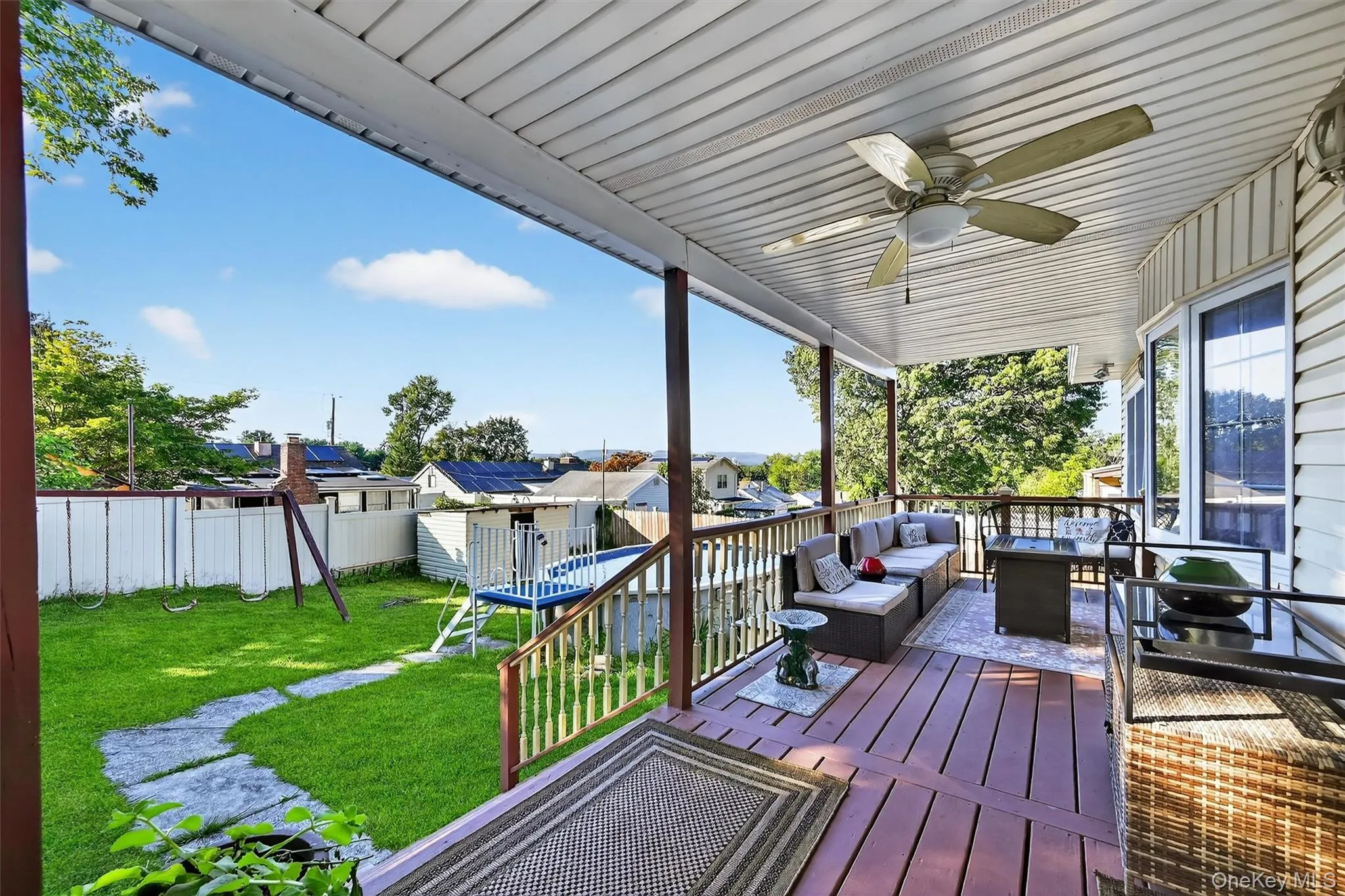 Wooden terrace with a fenced backyard, an outdoor living space, a residential view, and a ceiling fan Wooden terrace with a fenced backyard, an outdoor living space, a residential view, and a ceiling fan