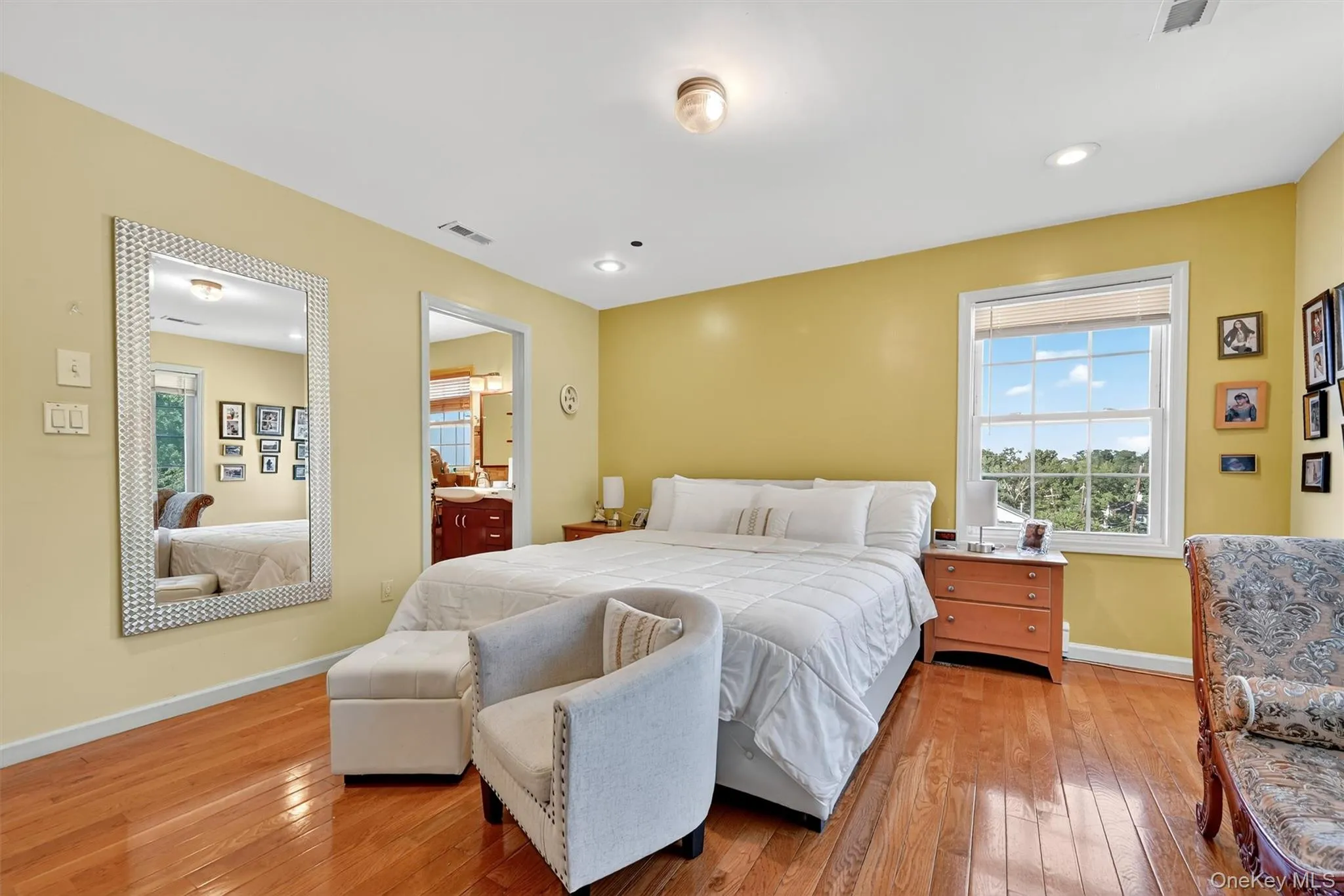 Bedroom with multiple windows, light wood-style flooring, and connected bathroom Bedroom with multiple windows, light wood-style flooring, and connected bathroom