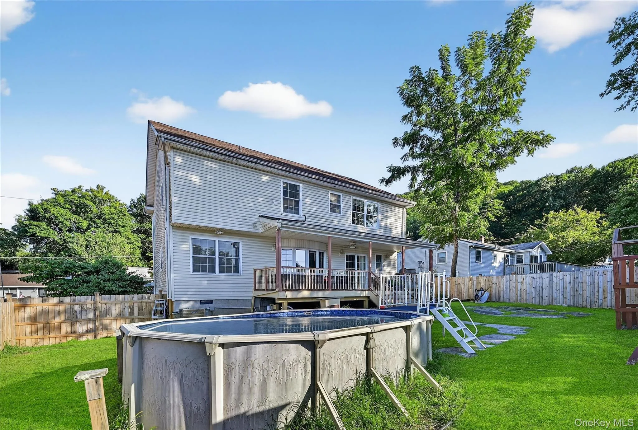 Rear view of property featuring a fenced backyard and a wooden deck Rear view of property featuring a fenced backyard and a wooden deck