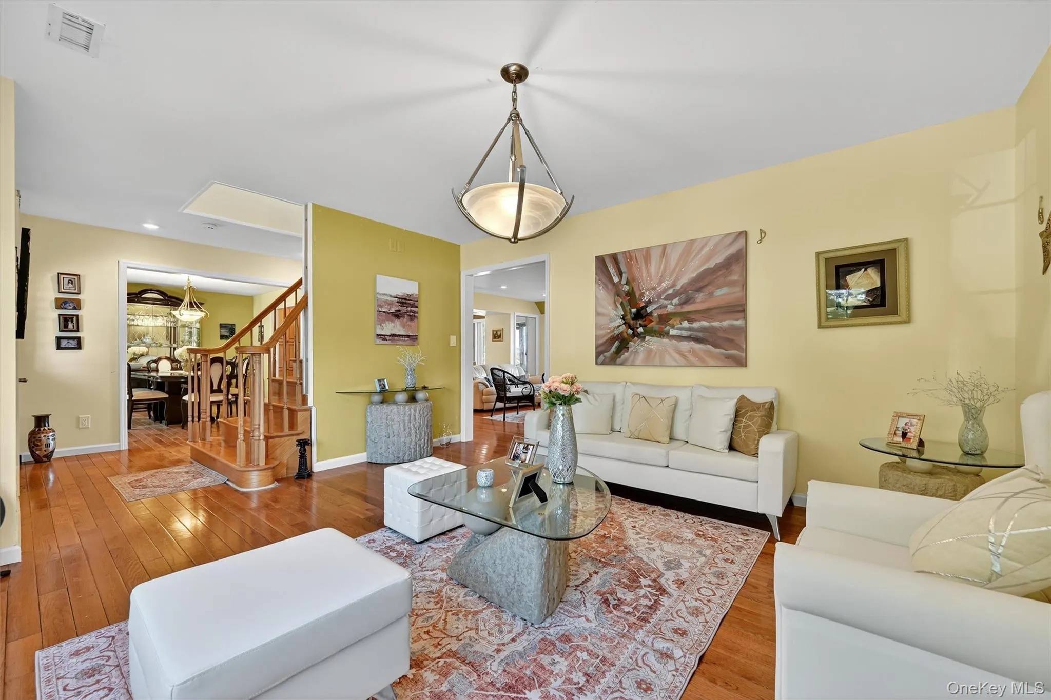 Living room featuring hardwood / wood-style flooring, stairs, and recessed lighting Living room featuring hardwood / wood-style flooring, stairs, and recessed lighting