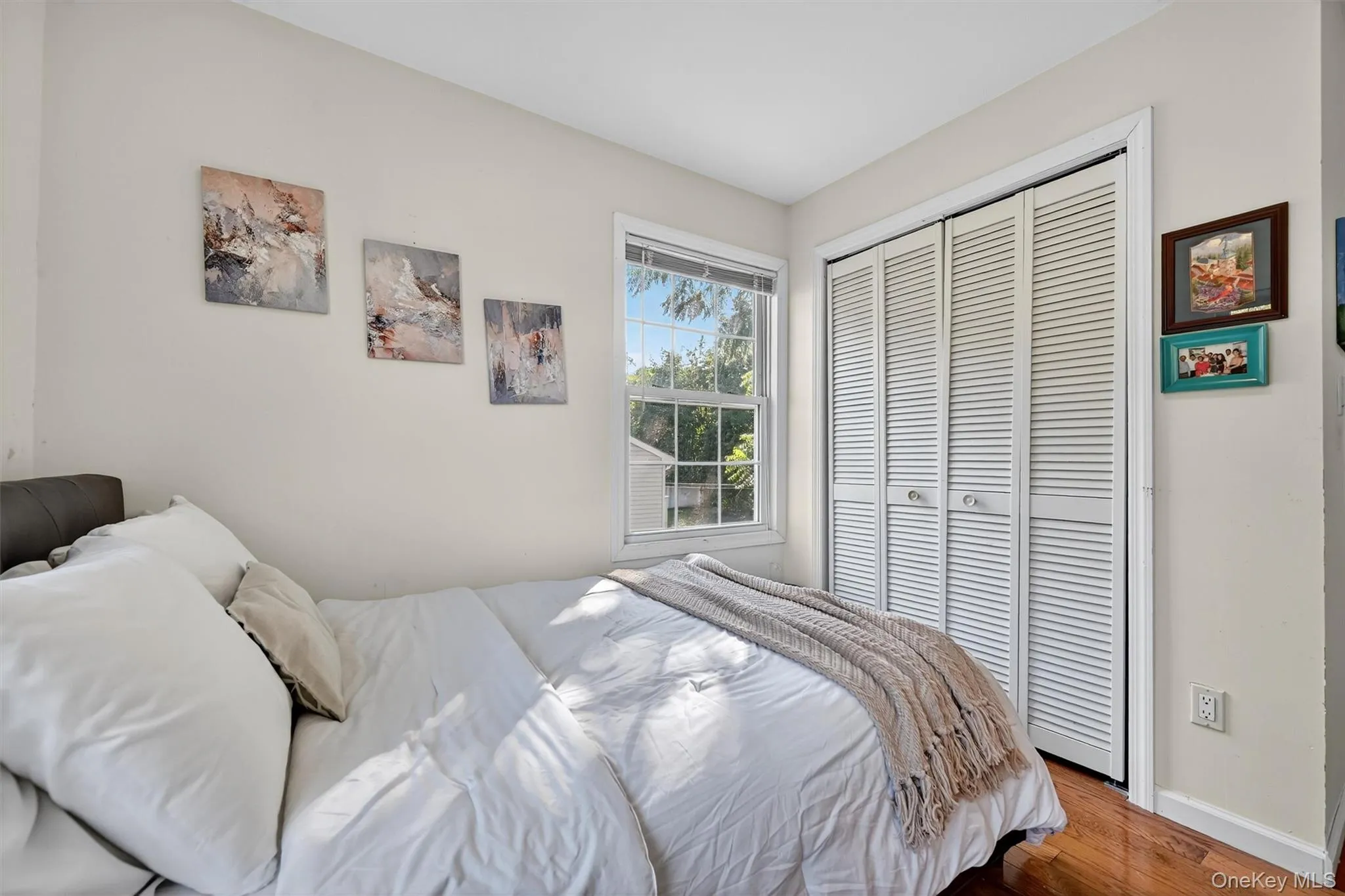 Bedroom featuring wood finished floors and a closet Bedroom featuring wood finished floors and a closet