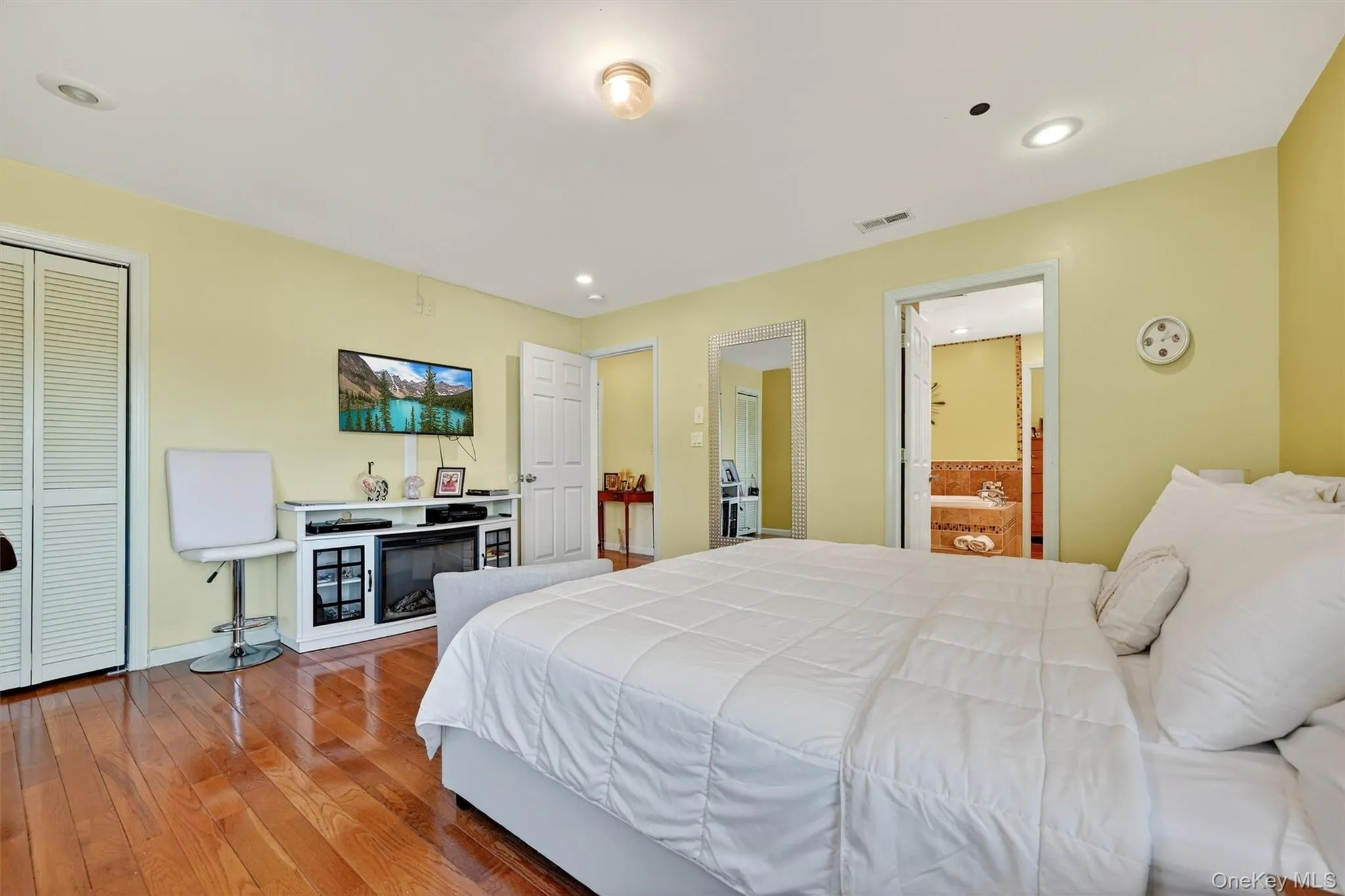 Bedroom with wood finished floors, recessed lighting, ensuite bath, and a closet Bedroom with wood finished floors, recessed lighting, ensuite bath, and a closet