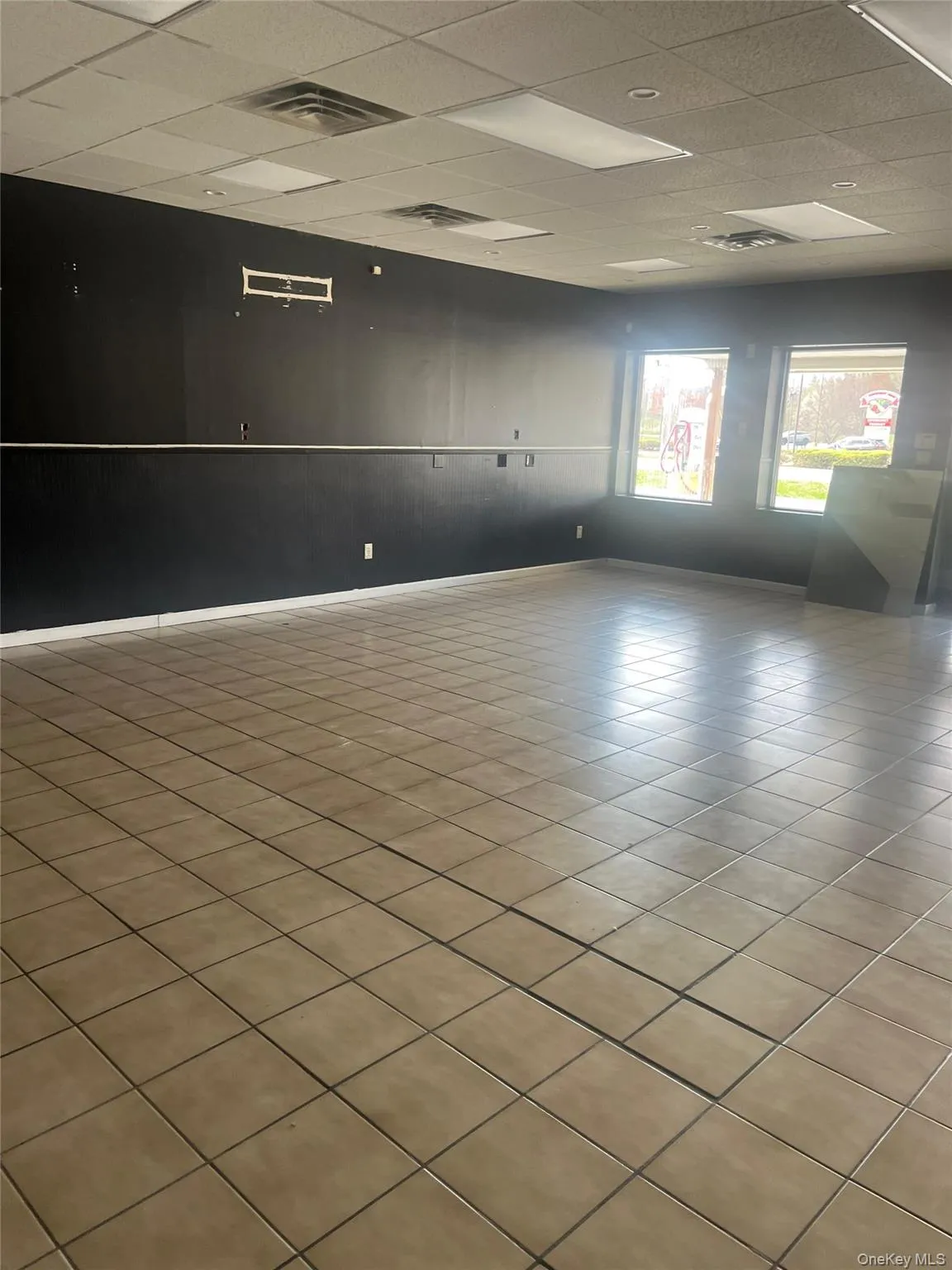 The property features a spacious interior with tiled flooring, dark-painted walls, and a suspended ceiling with integrated lighting The property features a spacious interior with tiled flooring, dark-painted walls, and a suspended ceiling with integrated lighting