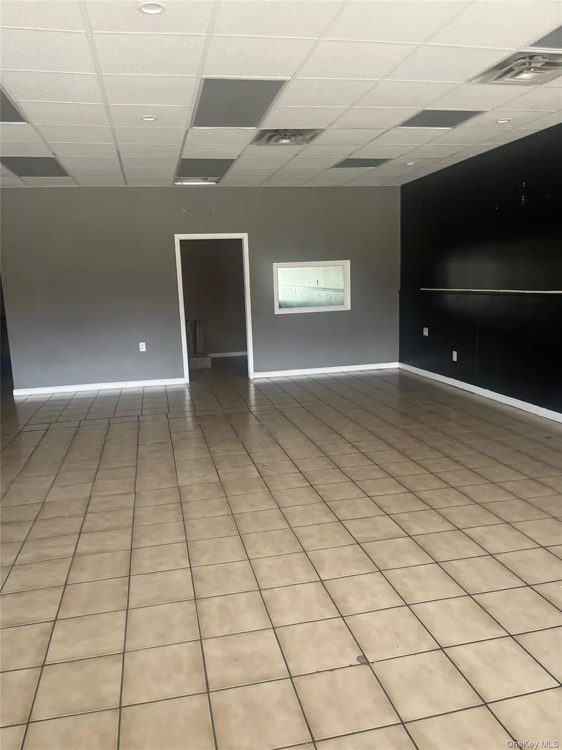The property features light-colored square tile flooring and a suspended ceiling with recessed lighting The property features light-colored square tile flooring and a suspended ceiling with recessed lighting