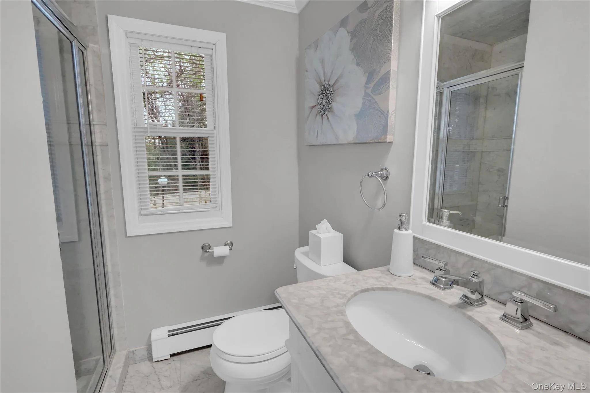 Bathroom featuring a single window, a built-in vanity with a stone countertop, an integrated sink, a mirrored medicine cabinet, and a glass-enclosed shower Bathroom featuring a single window, a built-in vanity with a stone countertop, an integrated sink, a mirrored medicine cabinet, and a glass-enclosed shower