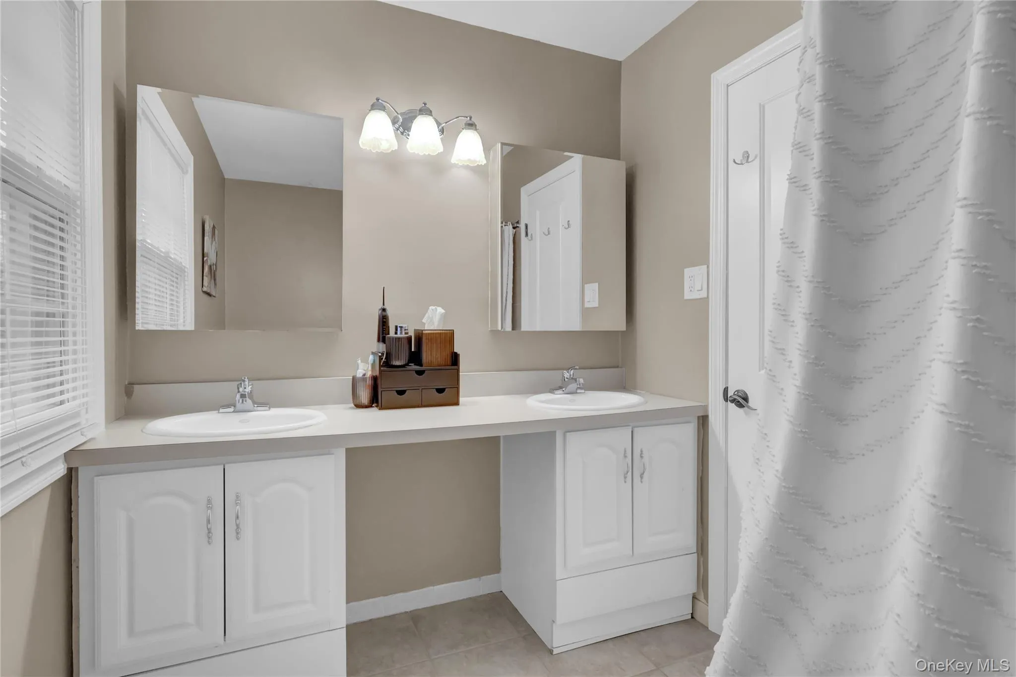 Double vanity with integral sinks and white cabinetry Double vanity with integral sinks and white cabinetry