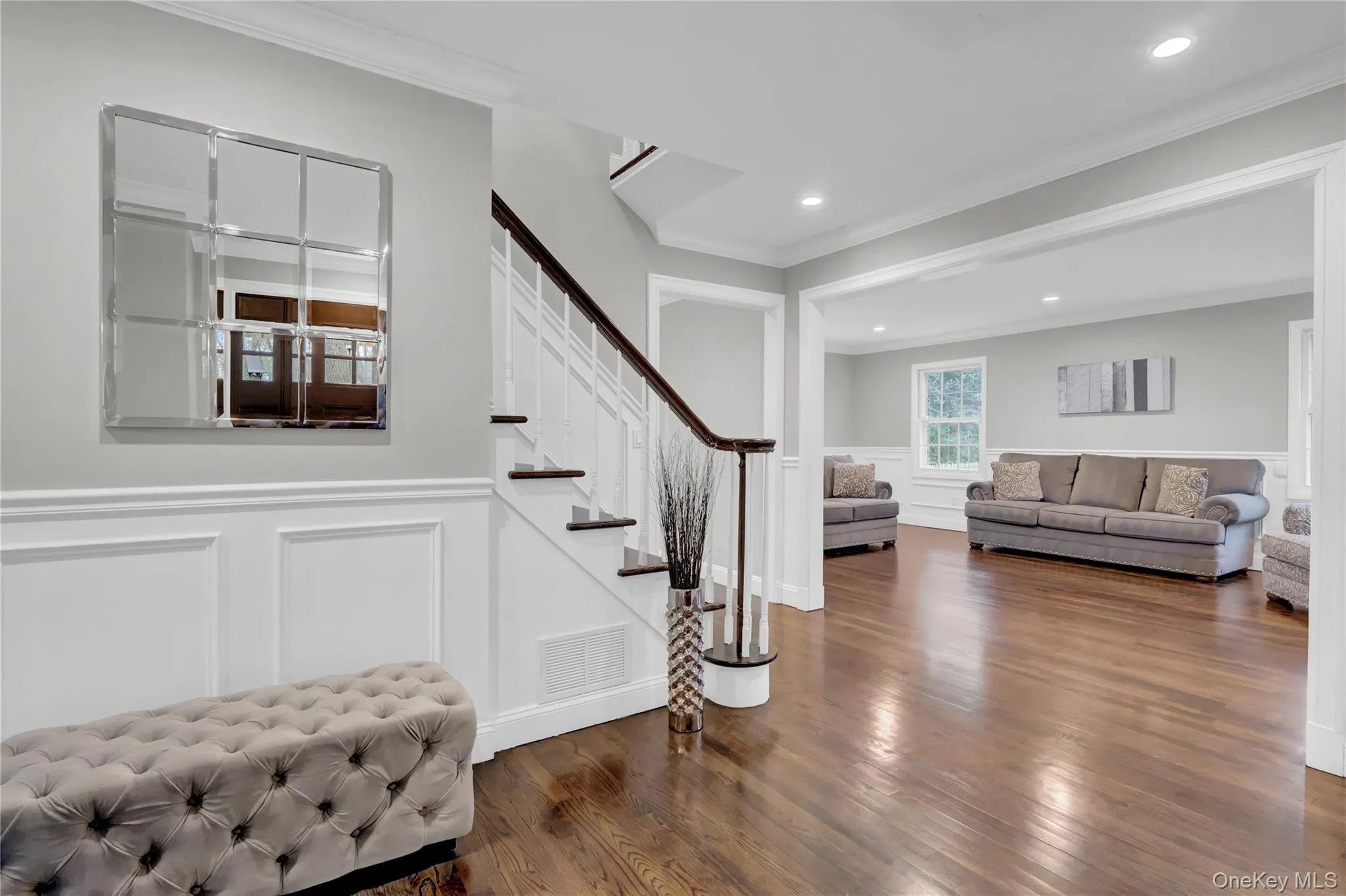 Hardwood flooring throughout the main level, featuring wainscoting and crown molding Hardwood flooring throughout the main level, featuring wainscoting and crown molding