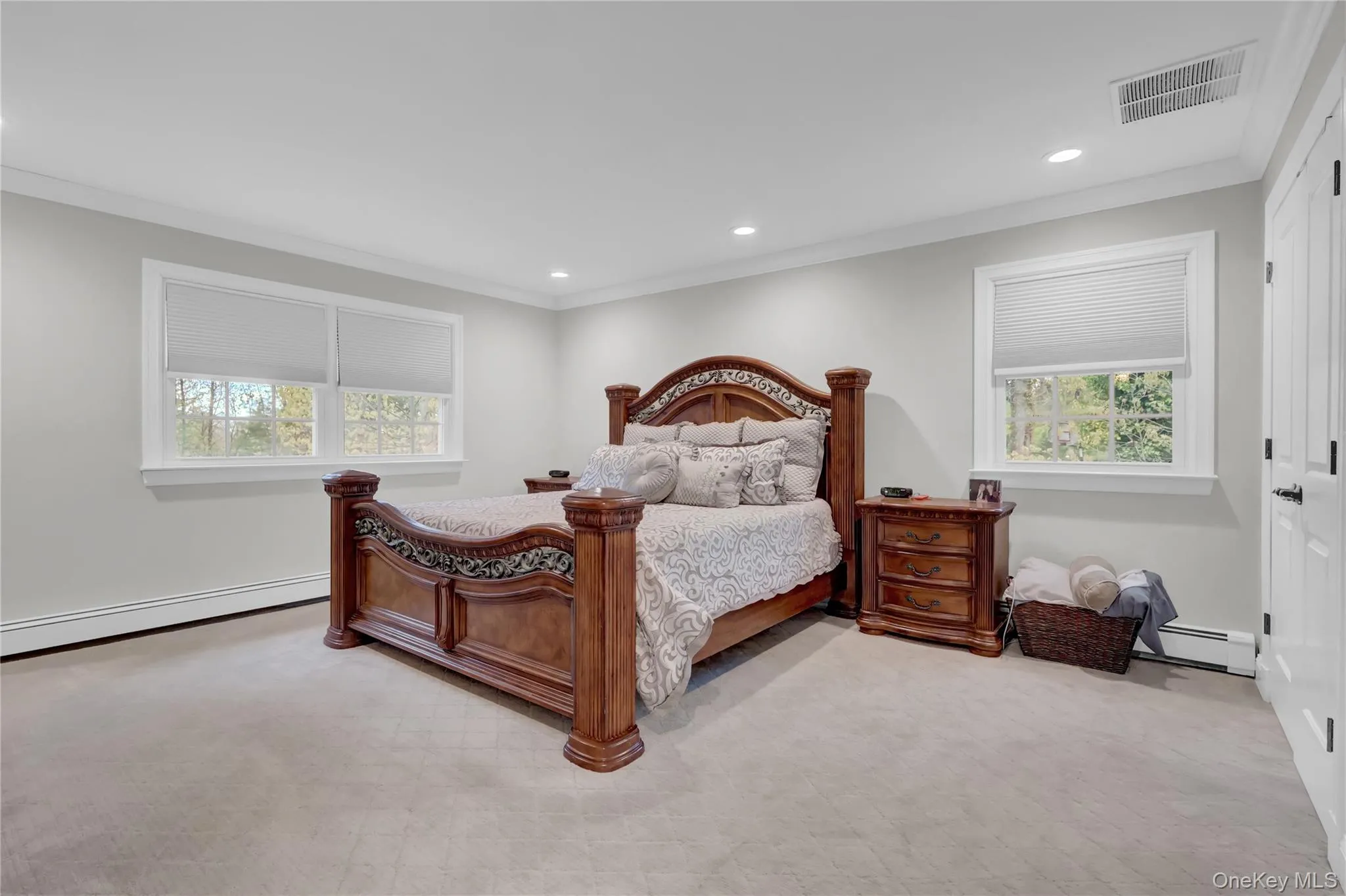 Spacious room featuring light-toned carpeting, white baseboards, and neutral wall paint Spacious room featuring light-toned carpeting, white baseboards, and neutral wall paint