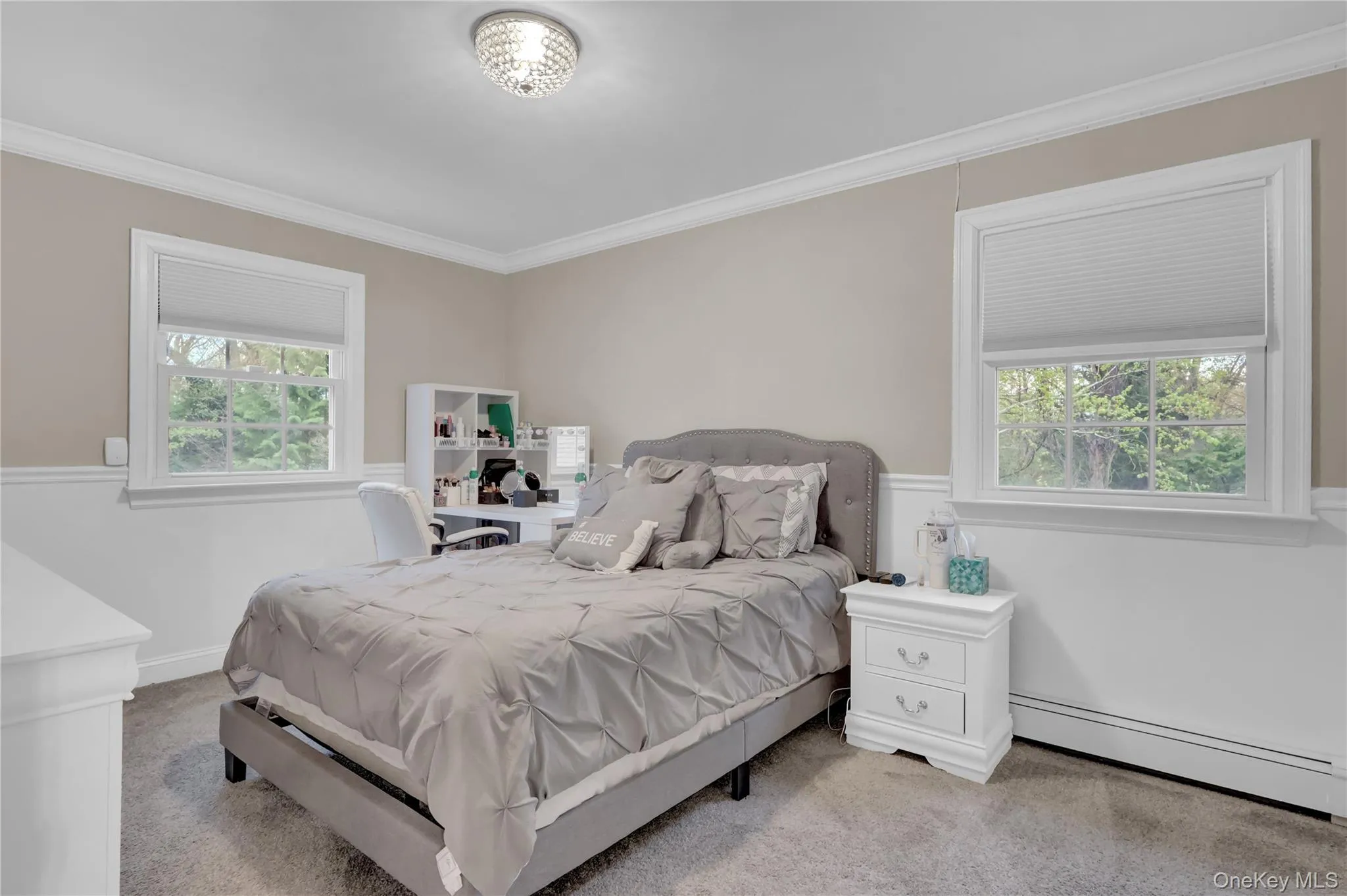 Bedroom featuring crown molding, two windows with blinds, a neutral color palette, and carpet flooring Bedroom featuring crown molding, two windows with blinds, a neutral color palette, and carpet flooring
