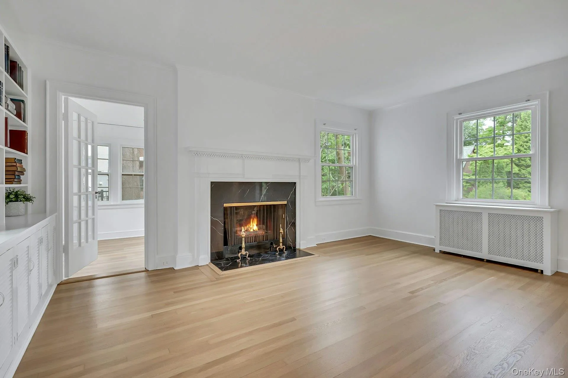Bright living room with fireplace and multiple window exposures Bright living room with fireplace and multiple window exposures