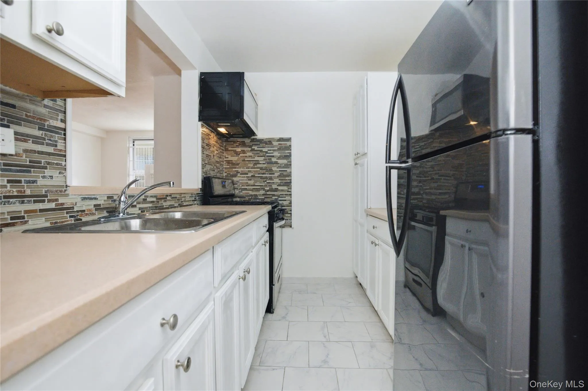 The kitchen features a double basin sink, granite countertop, backsplash, with stainless steel appliances The kitchen features a double basin sink, granite countertop, backsplash, with stainless steel appliances