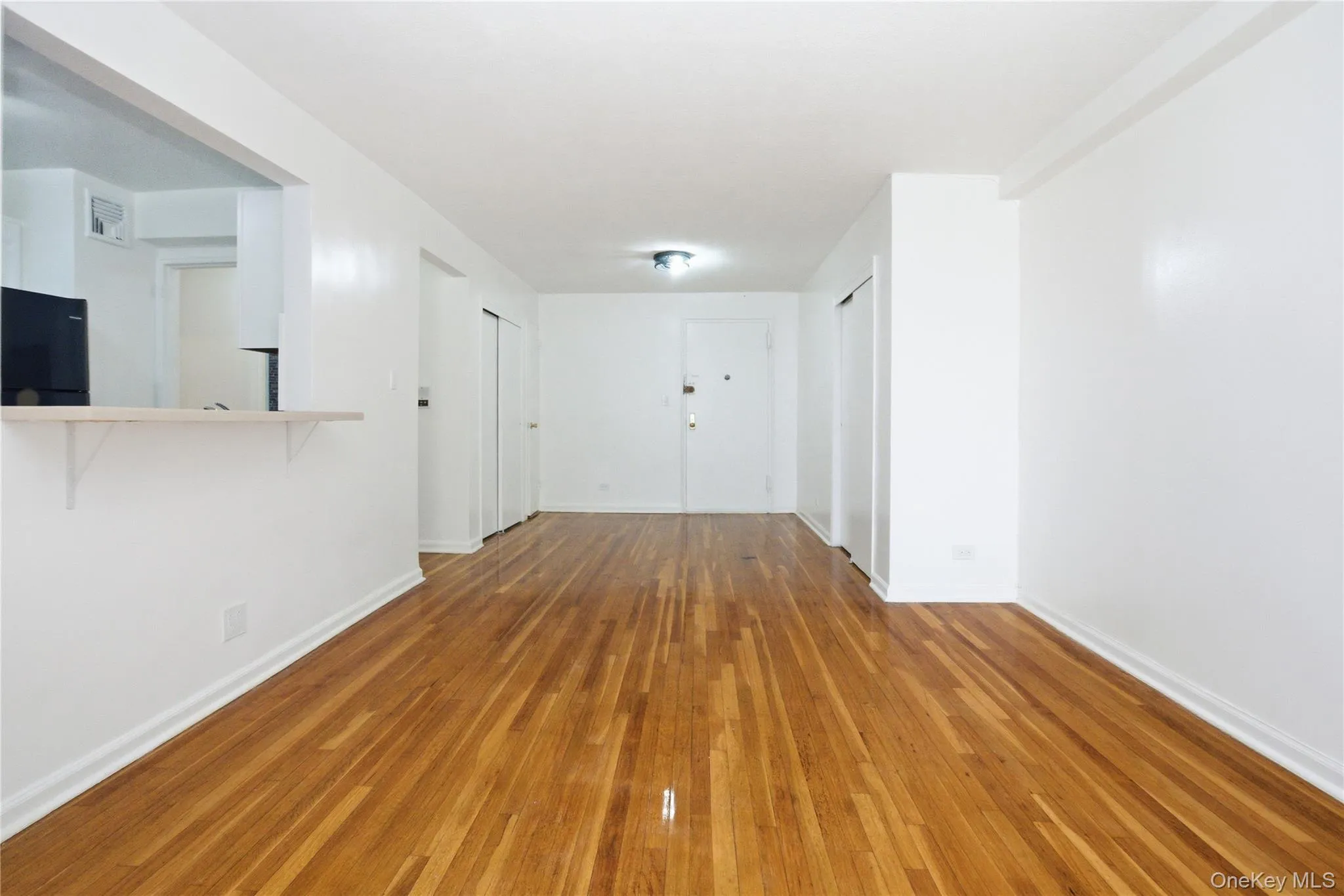 The property features hardwood floors, white walls, and a pass-through opening The property features hardwood floors, white walls, and a pass-through opening
