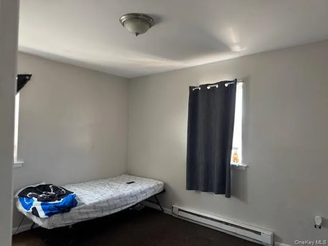 Bedroom featuring a baseboard heating unit and baseboards Bedroom featuring a baseboard heating unit and baseboards