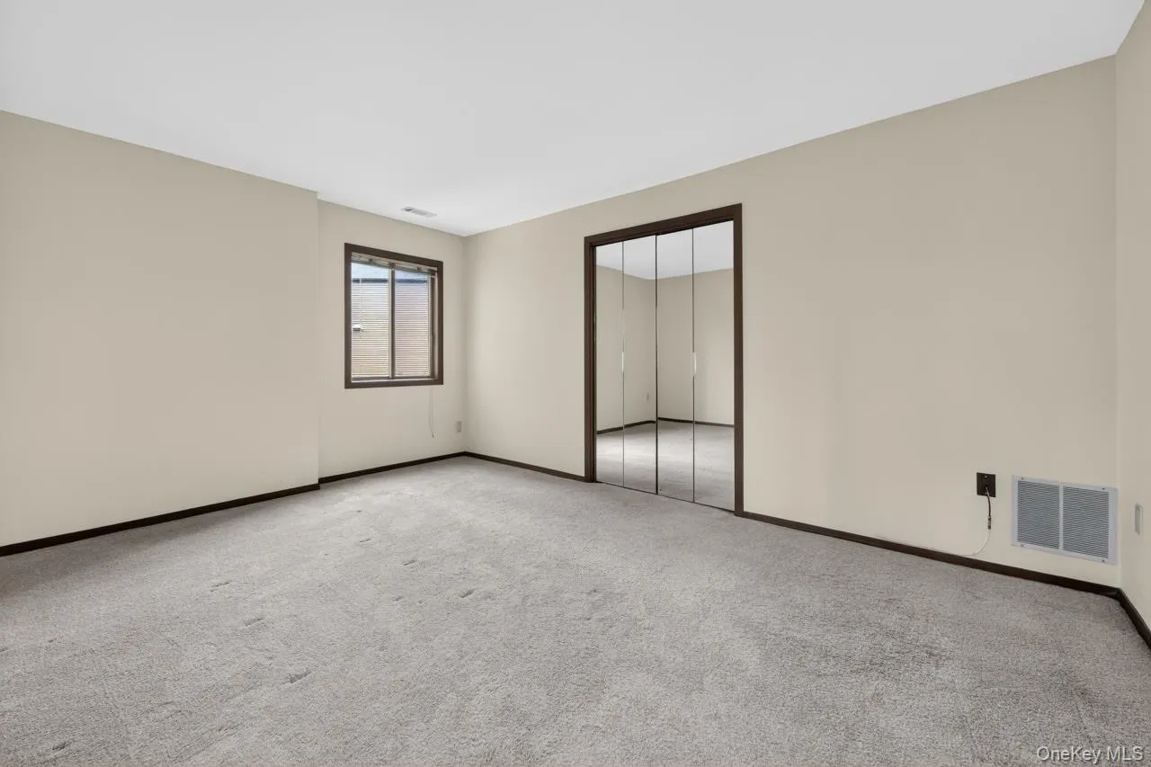 Carpeted room with neutral wall tones and dark trim Carpeted room with neutral wall tones and dark trim