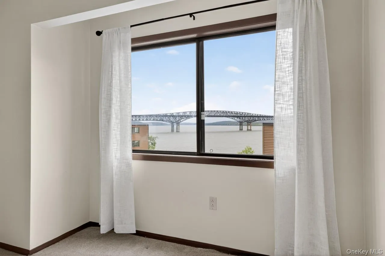 Large picture window framing a water body and distant bridge Large picture window framing a water body and distant bridge