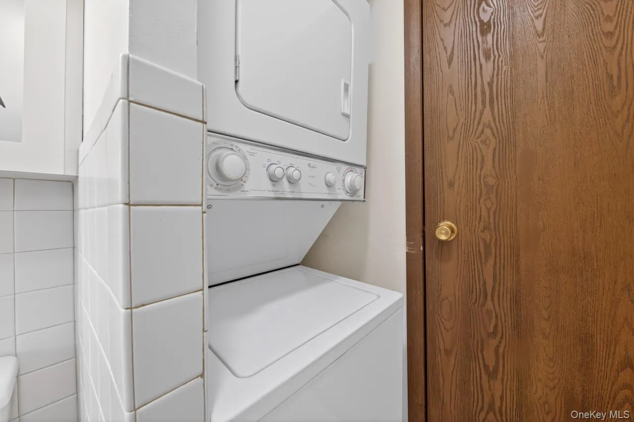 Stackable laundry appliances with white tile surround Stackable laundry appliances with white tile surround