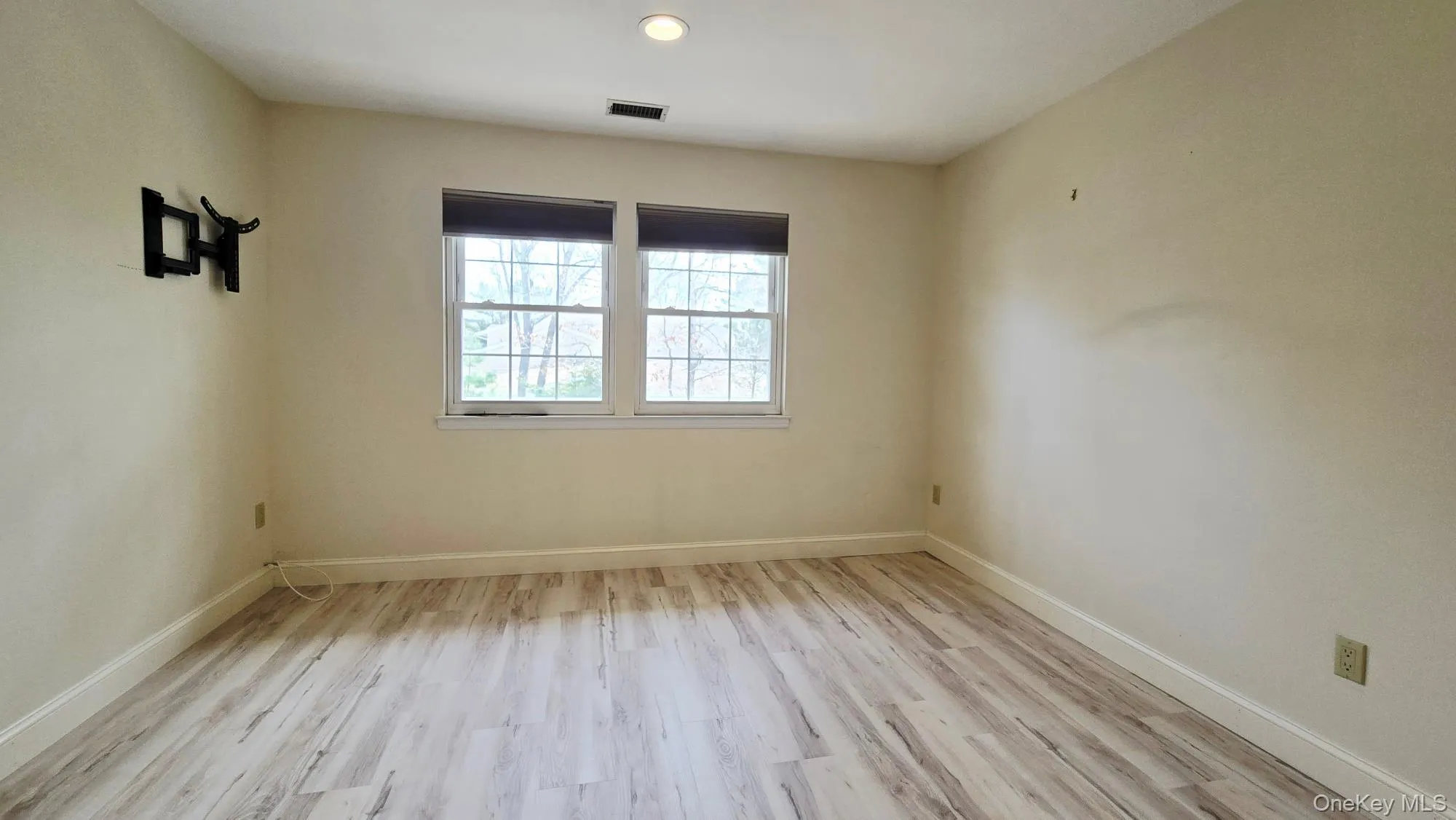 This room features light-colored walls, recessed ceiling lighting, and two windows providing natural light This room features light-colored walls, recessed ceiling lighting, and two windows providing natural light