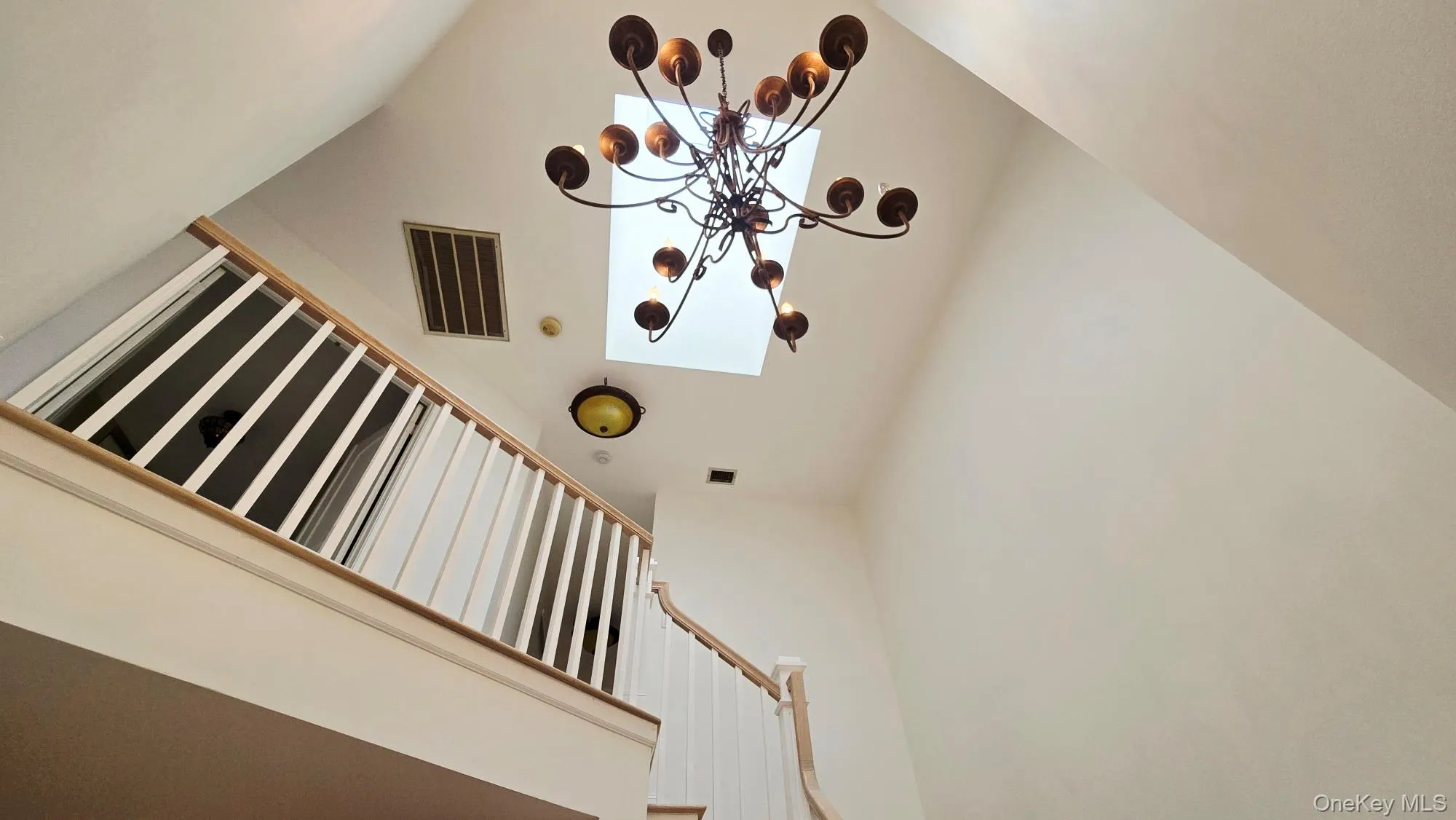 The property features an open stairway with white balusters and a light wood handrail, leading to a landing The property features an open stairway with white balusters and a light wood handrail, leading to a landing