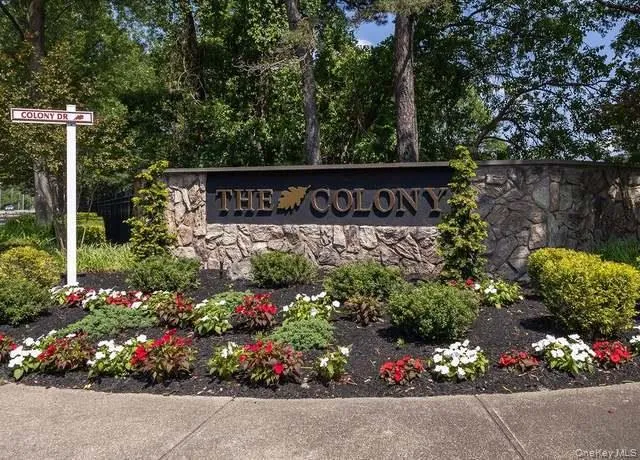 The property features an entrance sign crafted from natural stone, surrounded by decorative landscaping with various plants and colorful flowers The property features an entrance sign crafted from natural stone, surrounded by decorative landscaping with various plants and colorful flowers