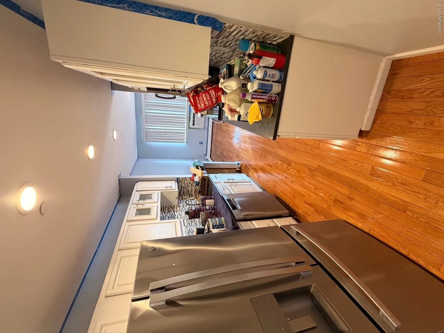 The kitchen features stainless steel appliances, white cabinetry, and a mosaic tile backsplash The kitchen features stainless steel appliances, white cabinetry, and a mosaic tile backsplash