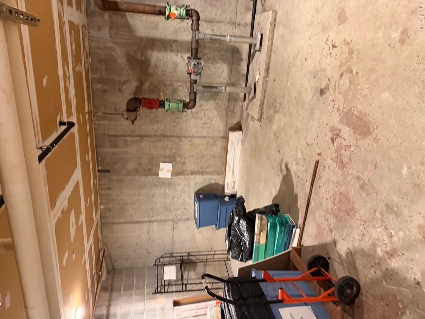 Unfinished basement space featuring concrete walls and exposed ceiling utilities Unfinished basement space featuring concrete walls and exposed ceiling utilities