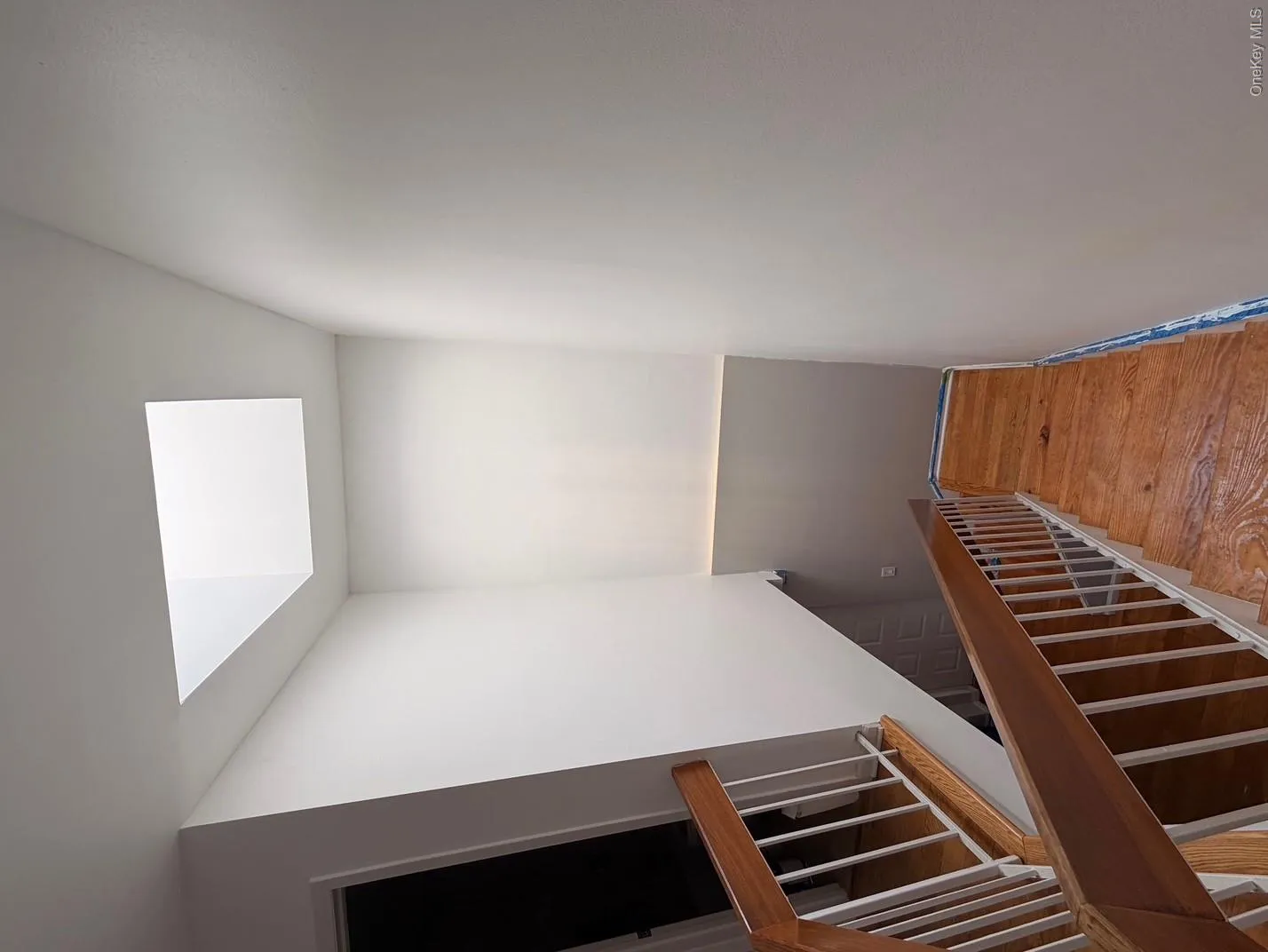 Stairwell with wood flooring and white balusters, featuring a skylight for natural illumination Stairwell with wood flooring and white balusters, featuring a skylight for natural illumination