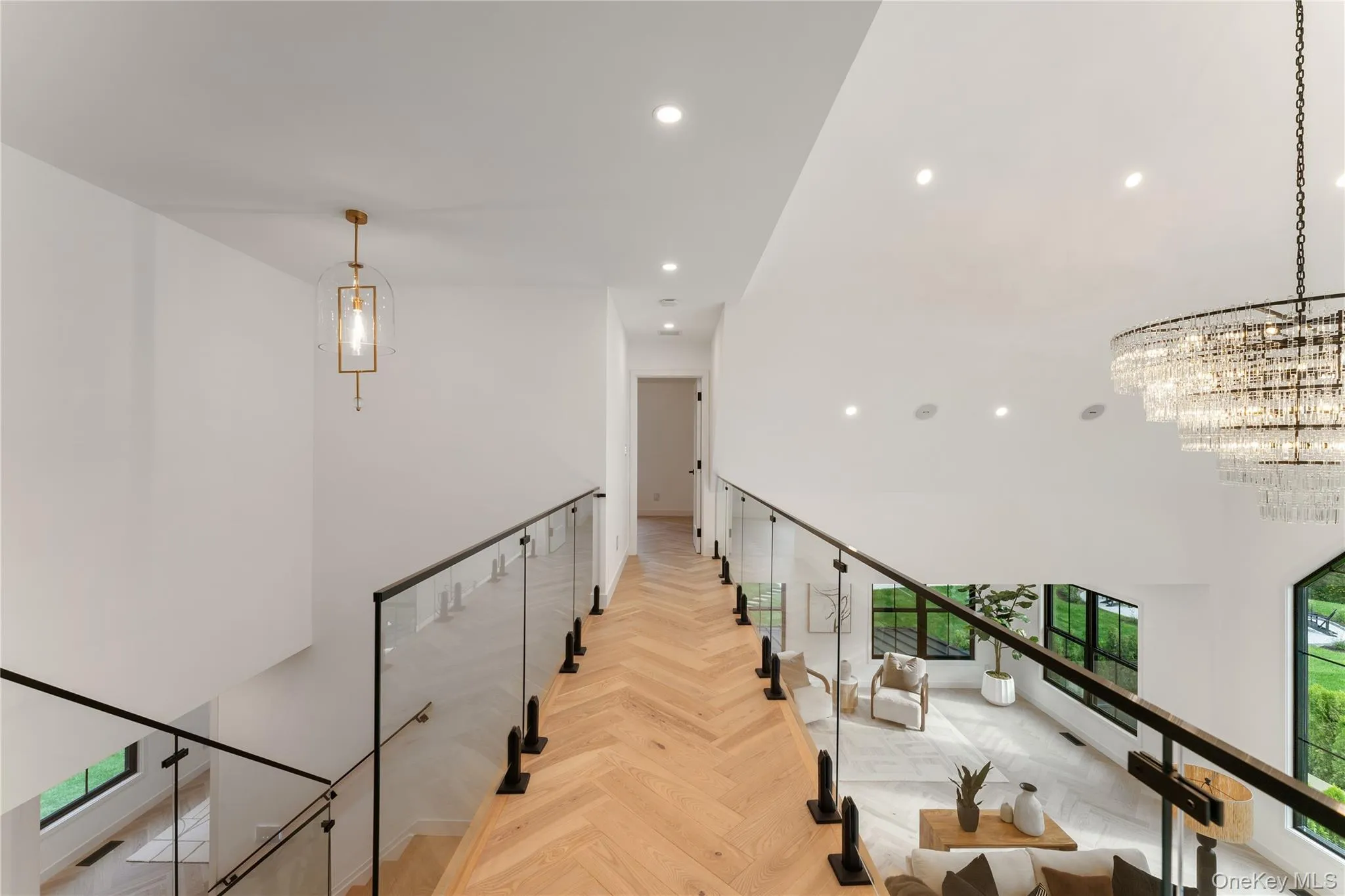 Corridor with recessed lighting, a chandelier, a towering ceiling, and an upstairs landing Corridor with recessed lighting, a chandelier, a towering ceiling, and an upstairs landing