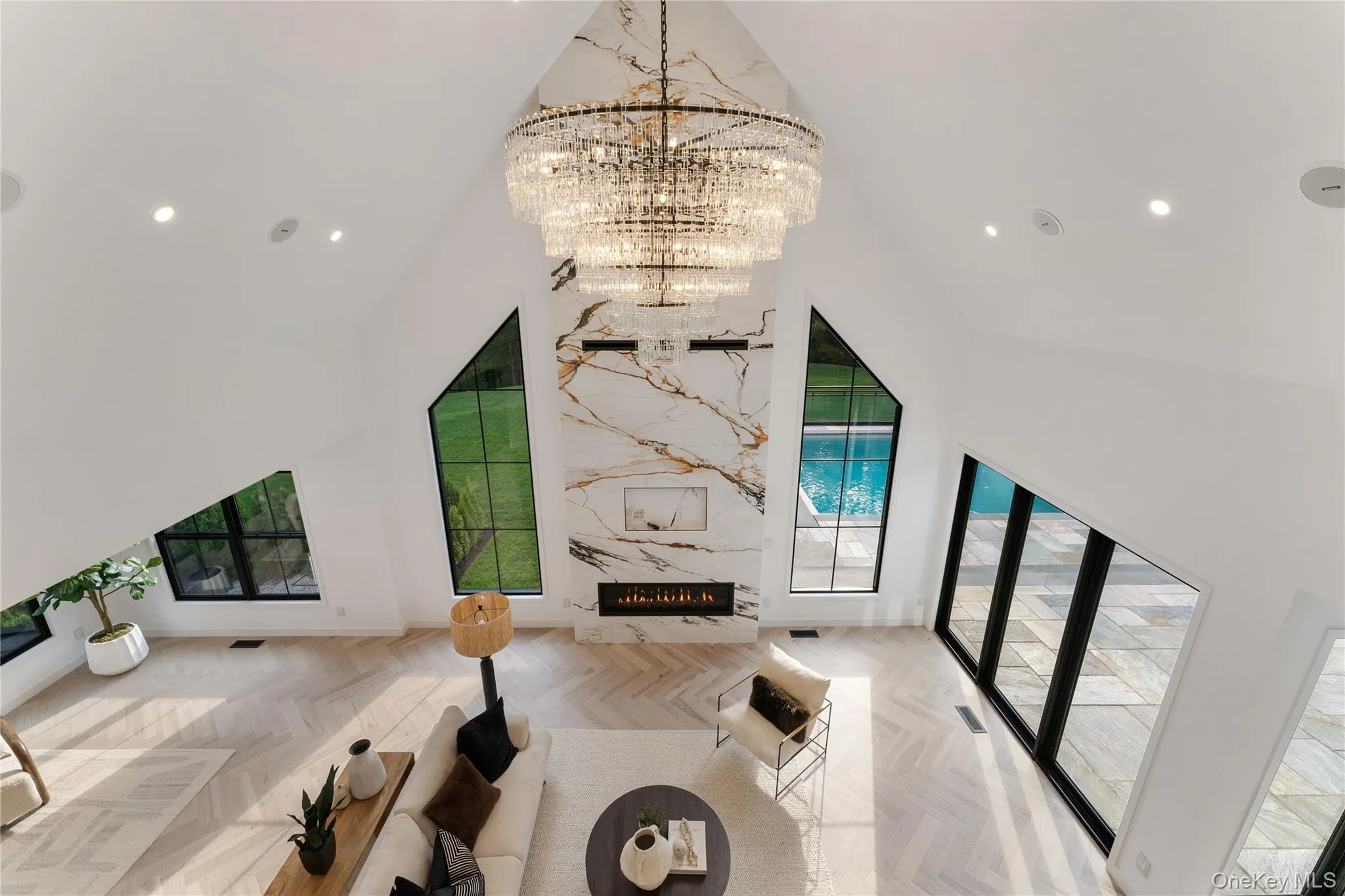 Living room with recessed lighting, a premium fireplace, high vaulted ceiling, and a chandelier Living room with recessed lighting, a premium fireplace, high vaulted ceiling, and a chandelier