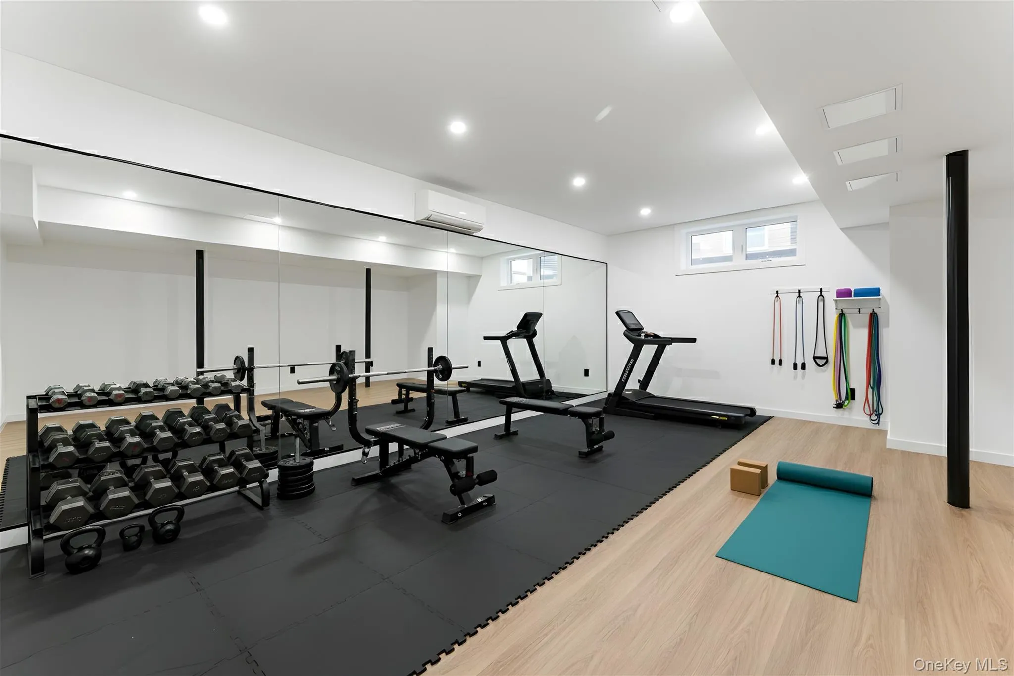 Home gym in basement featuring recessed lighting and a wall mounted air conditioner Home gym in basement featuring recessed lighting and a wall mounted air conditioner